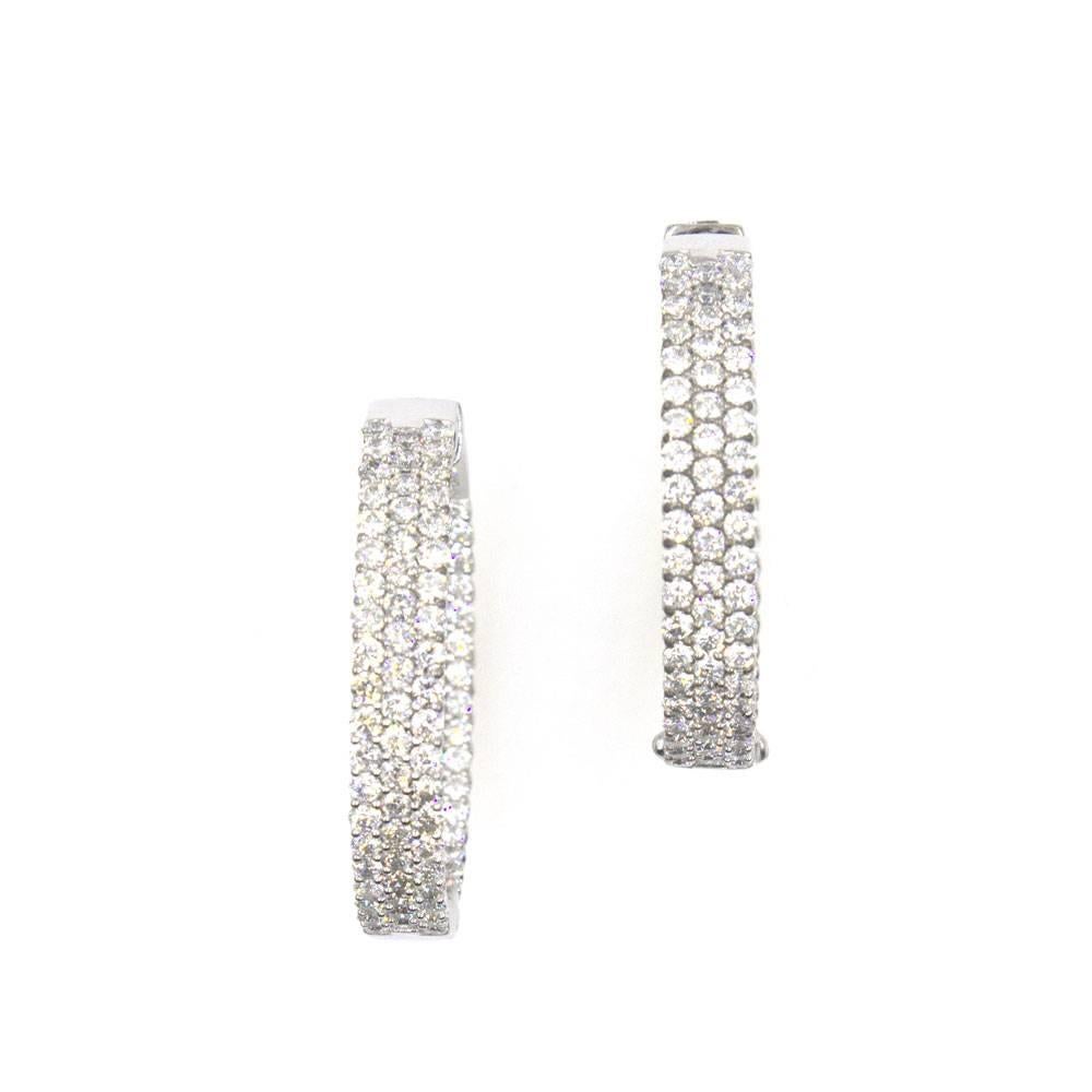 Stylish and brilliant characterize these timeless in and out hoop earrings. Three rows of in and out diamonds equal approximately 5.50 carat total weight of diamonds. The diamonds are graded G-H color and SI1-2 clarity. The hoops measure 1.25 inches