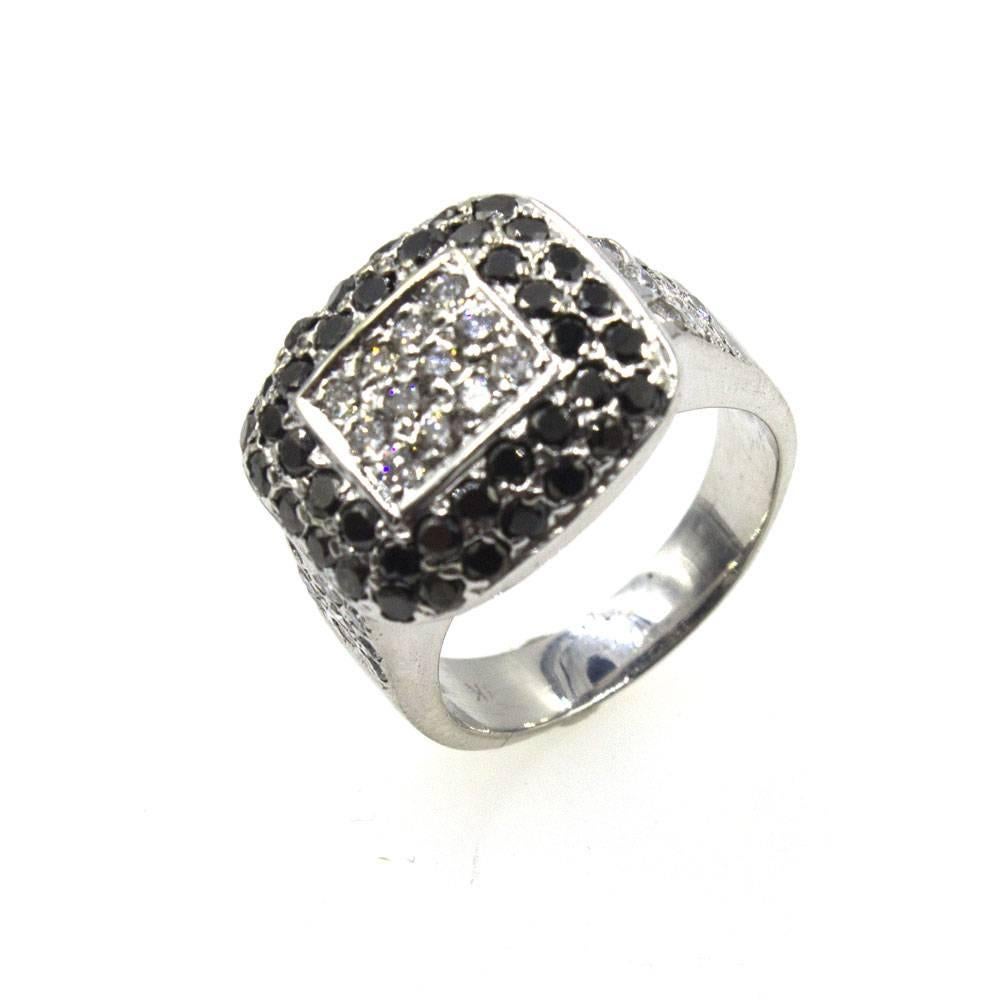 White and black diamonds are featured in this beautiful cocktail ring. Fashioned in 18 karat white gold, the ring features 1.80 carat of diamonds. The rectangular top measures 10 x 15mm and the ring is size 5.75 (can be sized).
