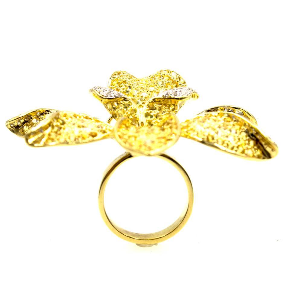 This fabulous floral ring stands out beautifully on the finger. The flower sparkles with white diamonds and yellow sapphires all set in 18 karat yellow gold. The beautifully crafted flower features .50 carat total weight of white diamonds and 12