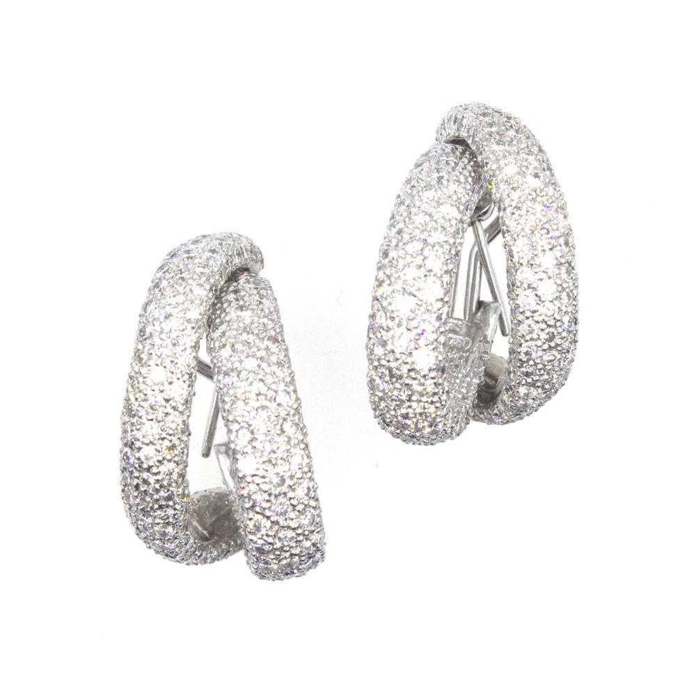 Sparkling with 10 carats of white diamonds, these gorgeous double hoop earrings are fashioned in 18 karat white gold. The earrings can be worn with posts or as clips (retractable posts) with omega backs. The pave set round brilliant cut diamonds are