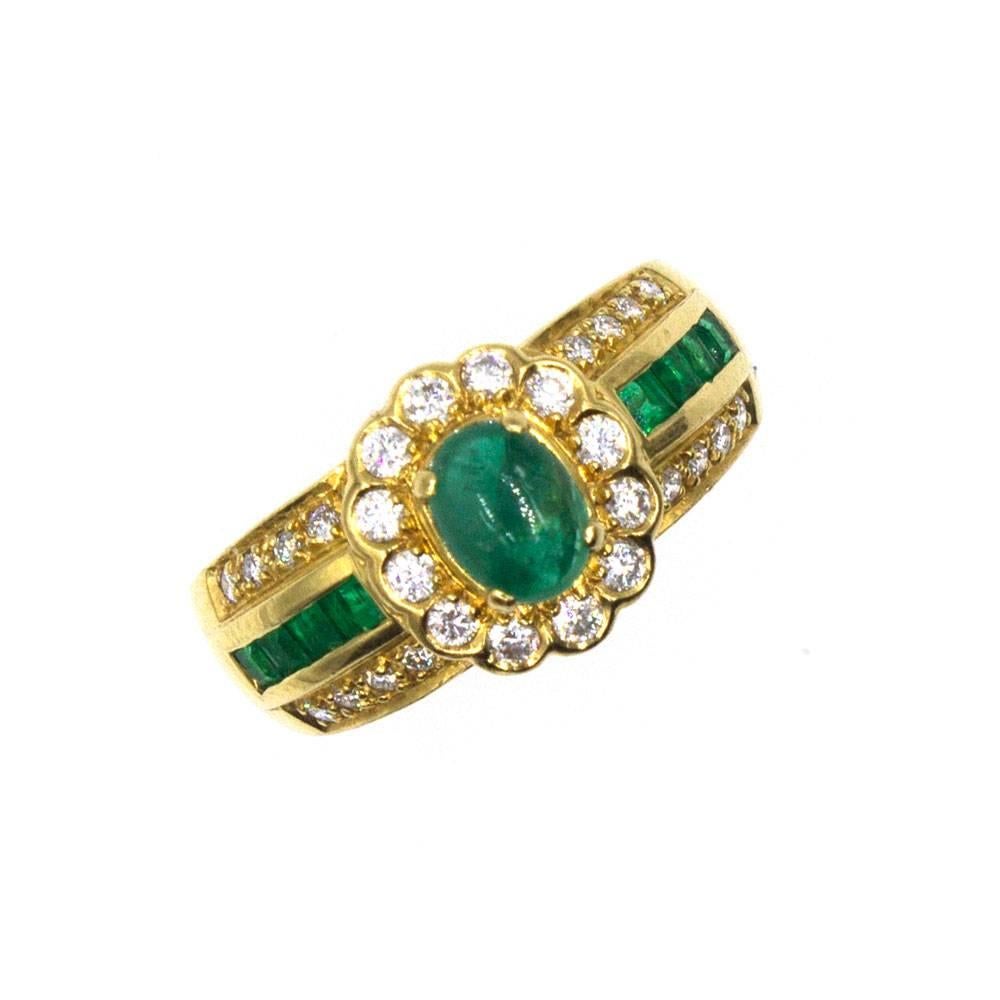 Beautiful emerald and diamond ring circa 1980's. Featuring a cabochon emerald center, the ring is accented with 28 round brilliant cut diamonds (approximately .50 carat total weight) and emeralds. Crafted in 18 karat yellow gold, the ring measures