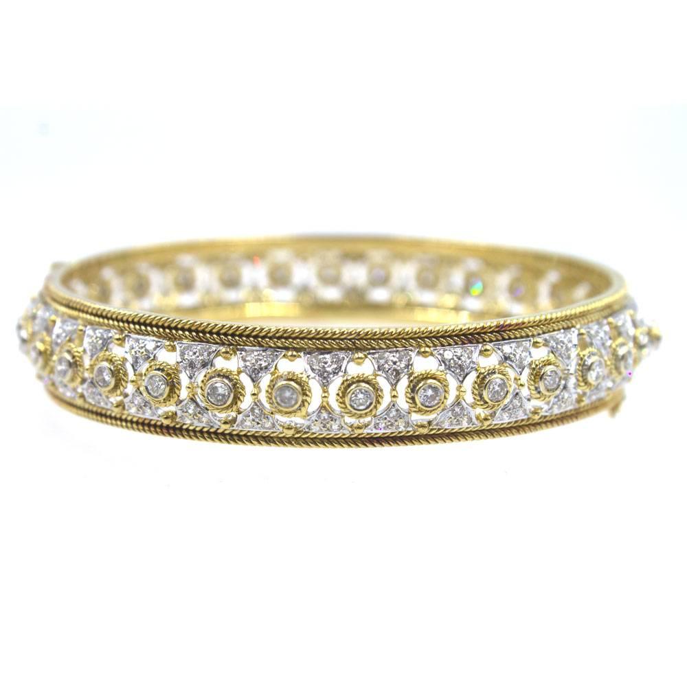 Beautifully crafted diamond and 18 karat gold bangle bracelet. The bangle features 3.00 carats of round brilliant cut diamonds graded H-I color and SI clarity. Measuring 12mm in width the bangle can be worn alone or stacked. 