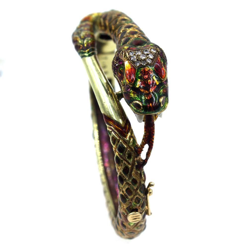 This vintage enamel snake bangle bracelet is fashioned in 18 karat yellow gold. Red and green enamel, diamonds and rubies make the snake bracelet come alive. The bangle measures 2 inches in diameter and will fit a 6-6.5 inch wrist (smaller size). 