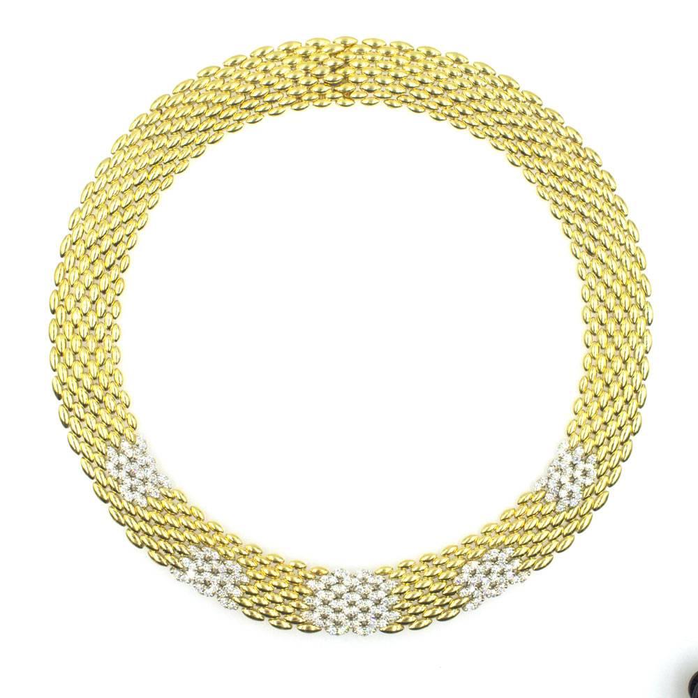 Seven carats of sparkling round brilliant cut diamonds are set throughout the nine row panther link necklace. Fashioned in 18 karat yellow gold, this collar necklace measures 16 inches in length and .60 inches in width. Signed Italy 18k. 
