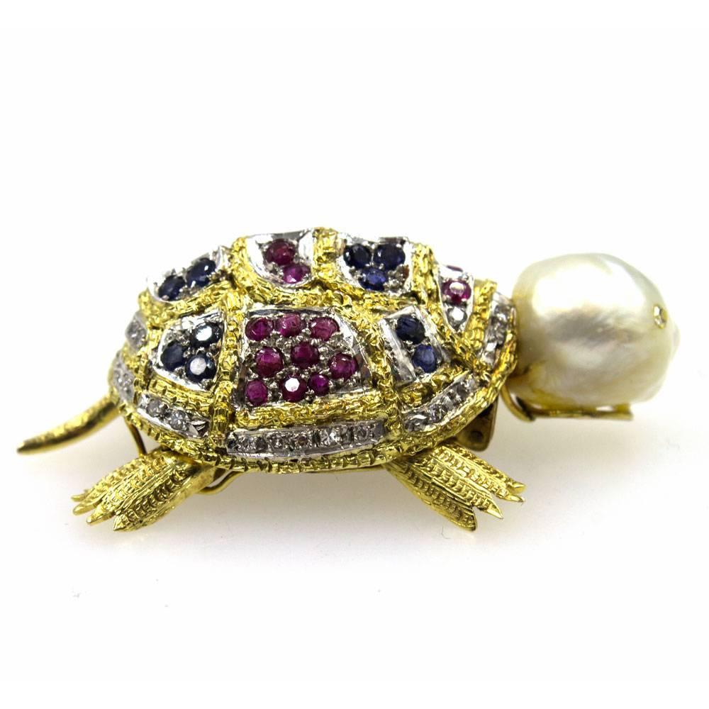 Absolutely adorable,  this vintage turtle brooch is hand crafted using diamonds, gemstones, and a pearl head. The pin is fashioned in 14 karat yellow gold and features mobile legs. There are 34 diamonds that equal approximately .36 carat total