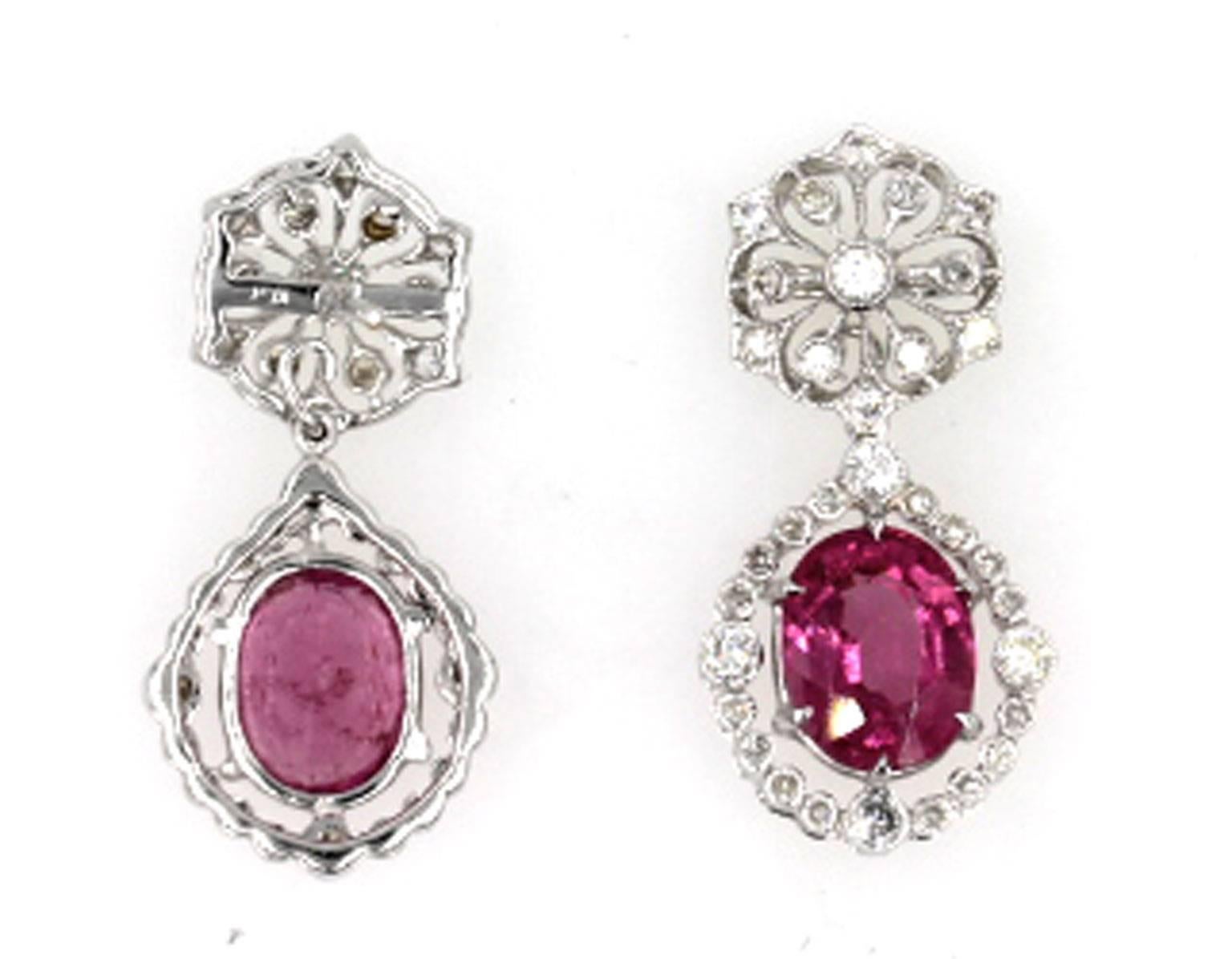 These brilliant diamond and pink tourmaline filigree earrings are fashioned in 18 karat white gold. There is approximately one carat total weight of diamonds in the filigree tops and surrounding the pink tourmalines. Each earring is 1 inch long and