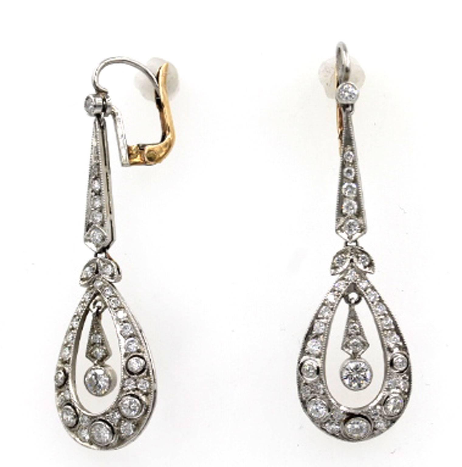These stunning diamond drop earrings are fashioned in platinum and 18 karat gold. There are approximately 1 1/4 carat total weight of diamonds. They measure 2 inches in length, and 1/2 inches in width. 