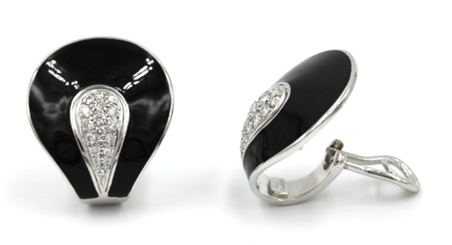 Stunning and fashionable 18 karat white gold earrings by designer Roberto Coin. These earrings feature .53 carat total weight of diamonds surrounded by black enamel. They have an omega back and retractable post so that they can be worn as clip on,