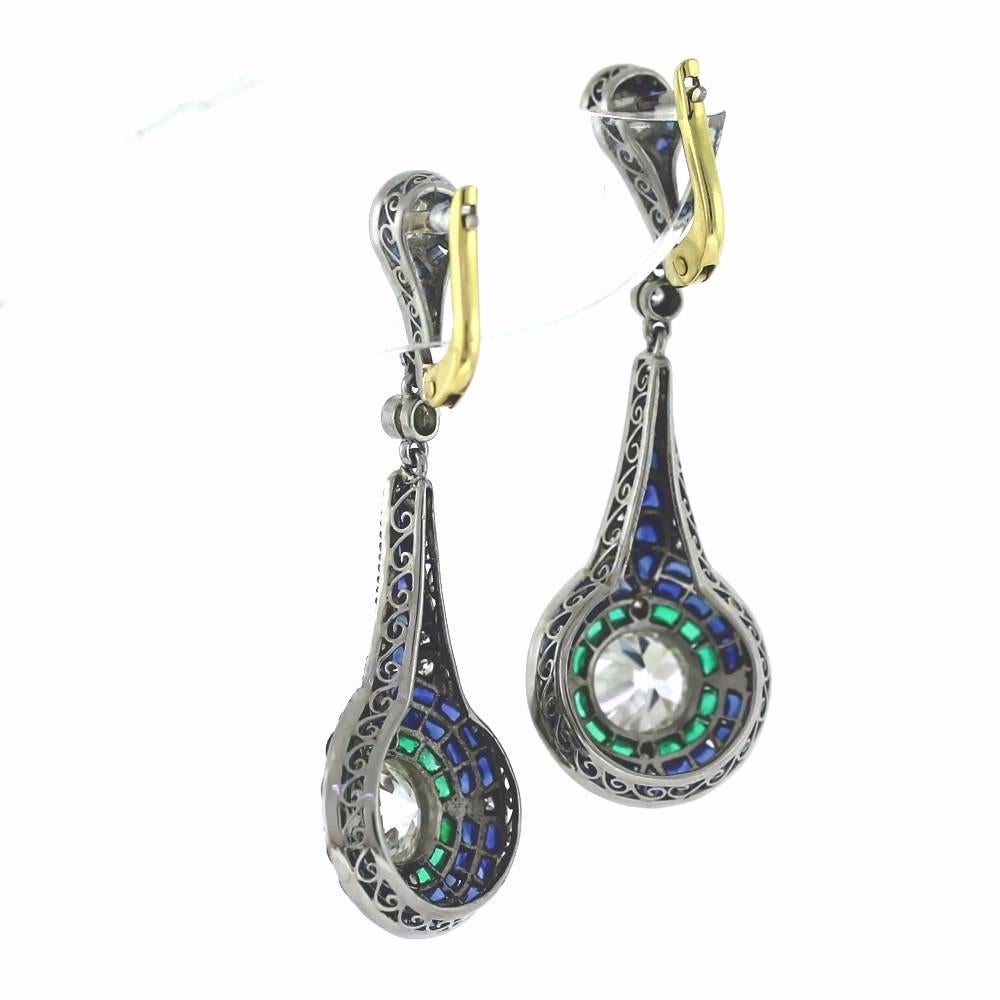Beautiful Platinum on Gold Lever back drop earrings using old stones to recreate and amazing pair of earrings.  The two large center diamonds are 2.71tcw with .70tcw in accent diamonds.  The buff-top sapphires and Emeralds have all been cut and