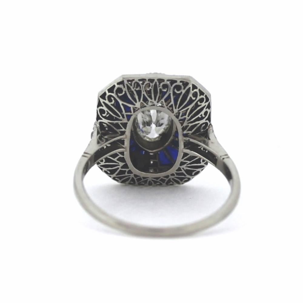 This handmade platinum ring has a center diamond that is an original antique oval cut with an open culet flanked by French cut sapphires and approx. .50 of old European cut diamonds.  Hand cut out gallery and amazing craftsmanship.  Sizeable size 7!