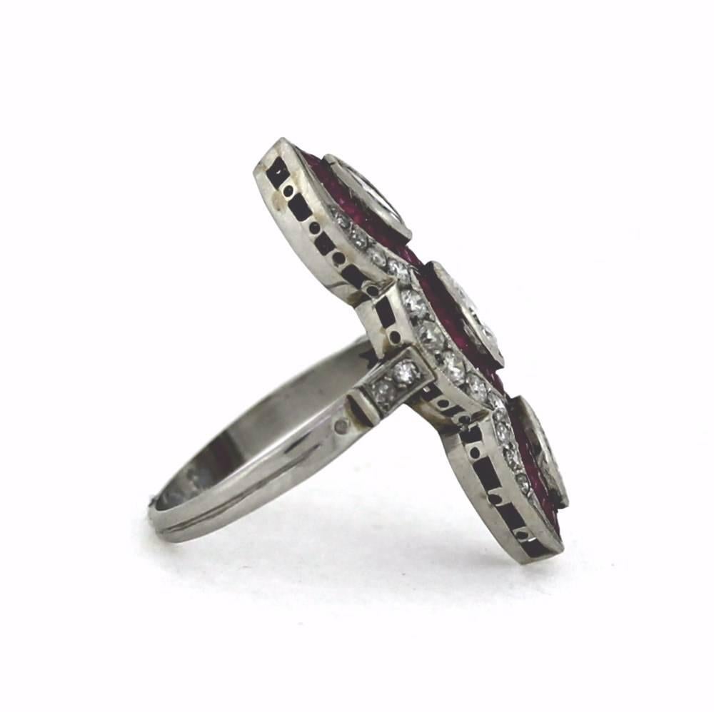 Platinum 1930's style with Milgrained edges adorn this very wearable diamond ring.  The nice pop of ruby red gives the uniqueness assuring no one will be copying your style!  Size 6.5, sizable.  [3MQ=1.20][28DIA=.60]French Cut Ruby 7.5gr