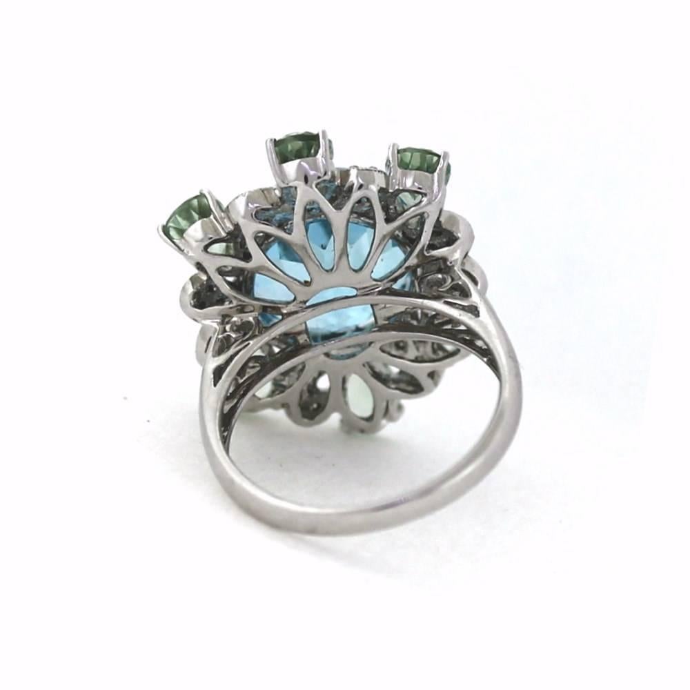 Magnificent rare color of blue Topaz ring with green pear shaped quartz surrounding the center stones.  The center stone topaz weights approximately 7.00 carats and consists of .20ctw of round white diamonds.  This ring is an eye popper featuring