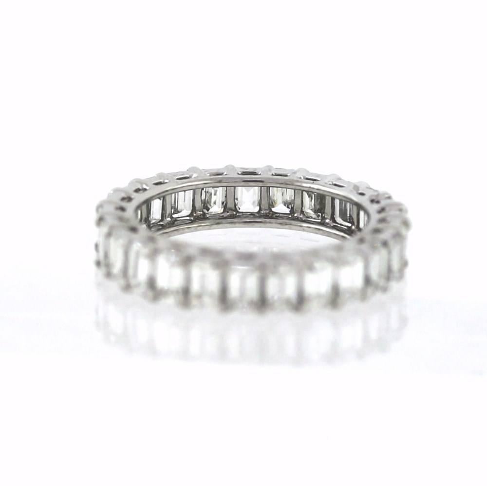 Beautiful hand finished eternity band made of platinum containing 25 emerald cut diamonds weighing a total of 6.11 carats.  The diamonds are G-H color and VS clarity.  The band is a size 6 1/2 and can be sized up or down upon request.  