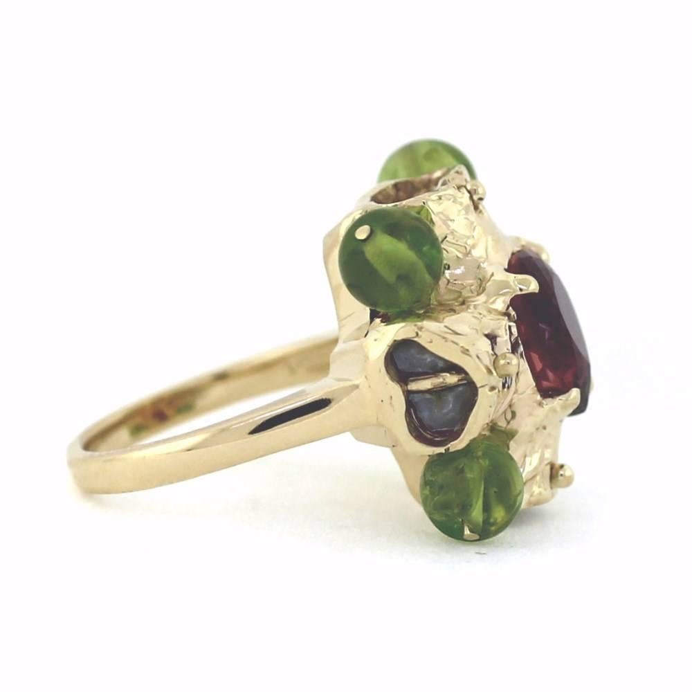 Beautiful Pear Shape Tourmaline featured in the center surrounded by 14k yellow gold and 4 green peridot gem stone beads.  The tourmaline weighs approximately 4 carats.  This ring is an awesome colorful 70's look!

This ring is a size 7 but can be