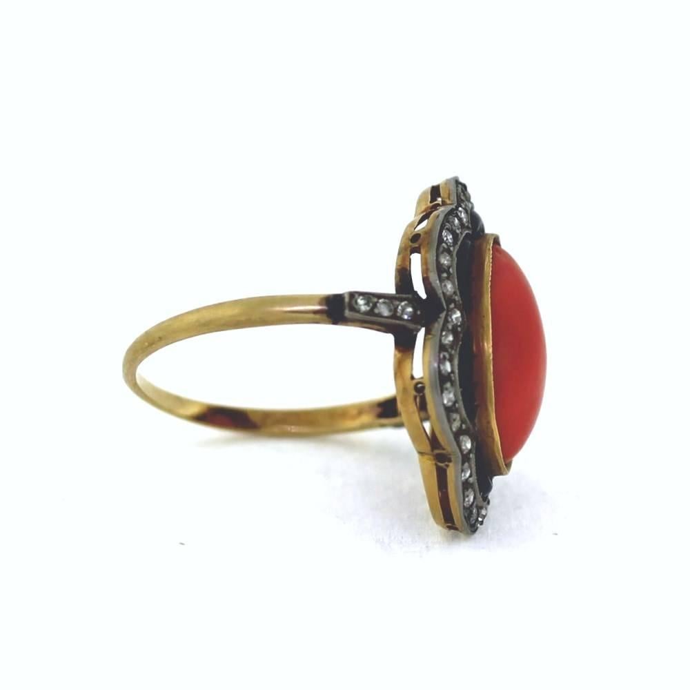 Beautiful  18k yellow gold ring featuring coral in the center surrounded by black onyx and approximately .40 carats of diamonds.  The ring is sizable to any size.