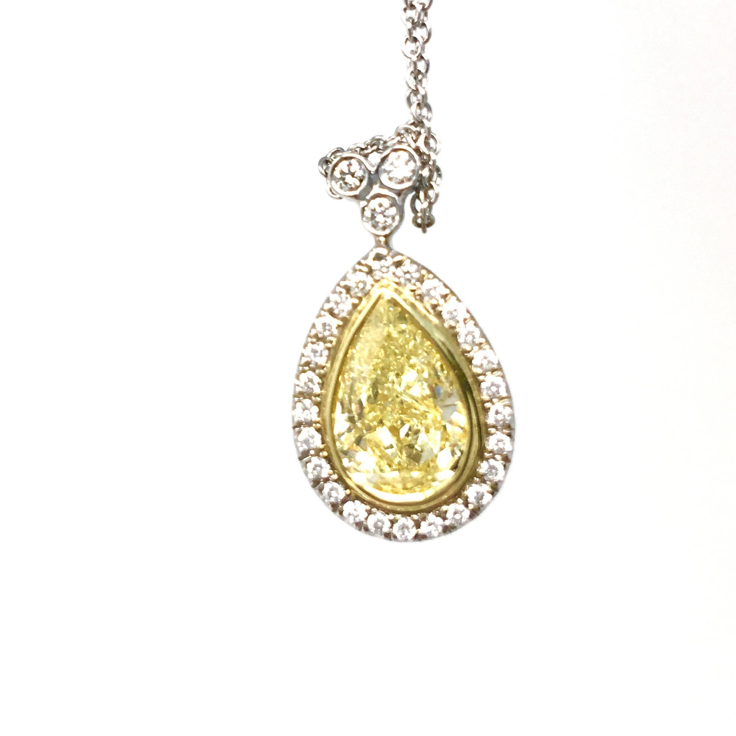 Pendant featuring a beautiful 1.51 carat pear shape yellow diamond.  The center is diamond is surrounded by 26 white diamonds totaling .60ctw.  Over 2 carats total of diamonds in the pendant.  The Diamond is set in 18K yellow gold and platinum. 
GIA