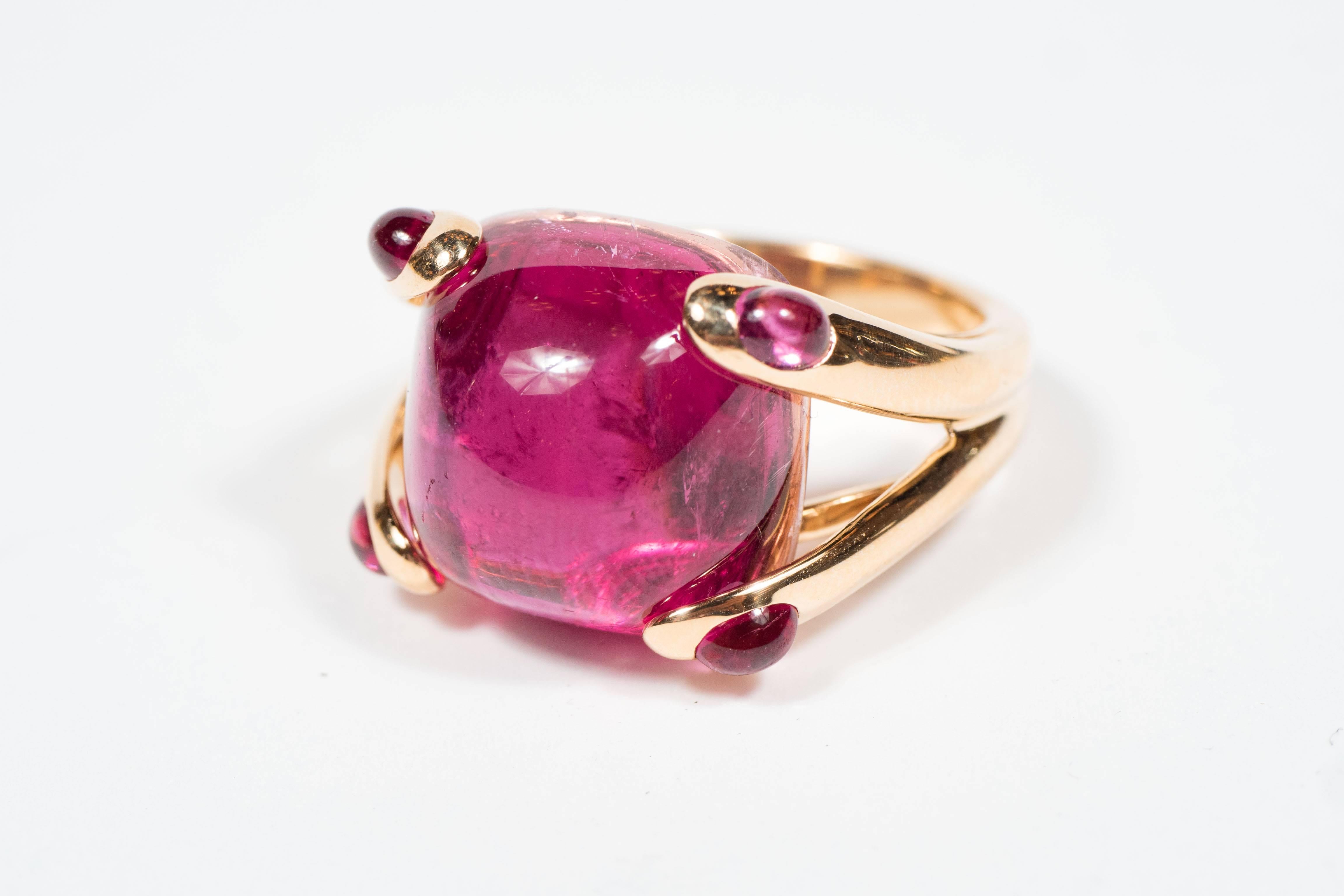This exquisite rubelite and 18-karat yellow gold "Candy" ring was hand crafted in Italy by the celebrated maker Verdura circa 1968. Centered is one cushion-shaped rubellite weighing approximately 23 carats, cornered by 4 round rubellite