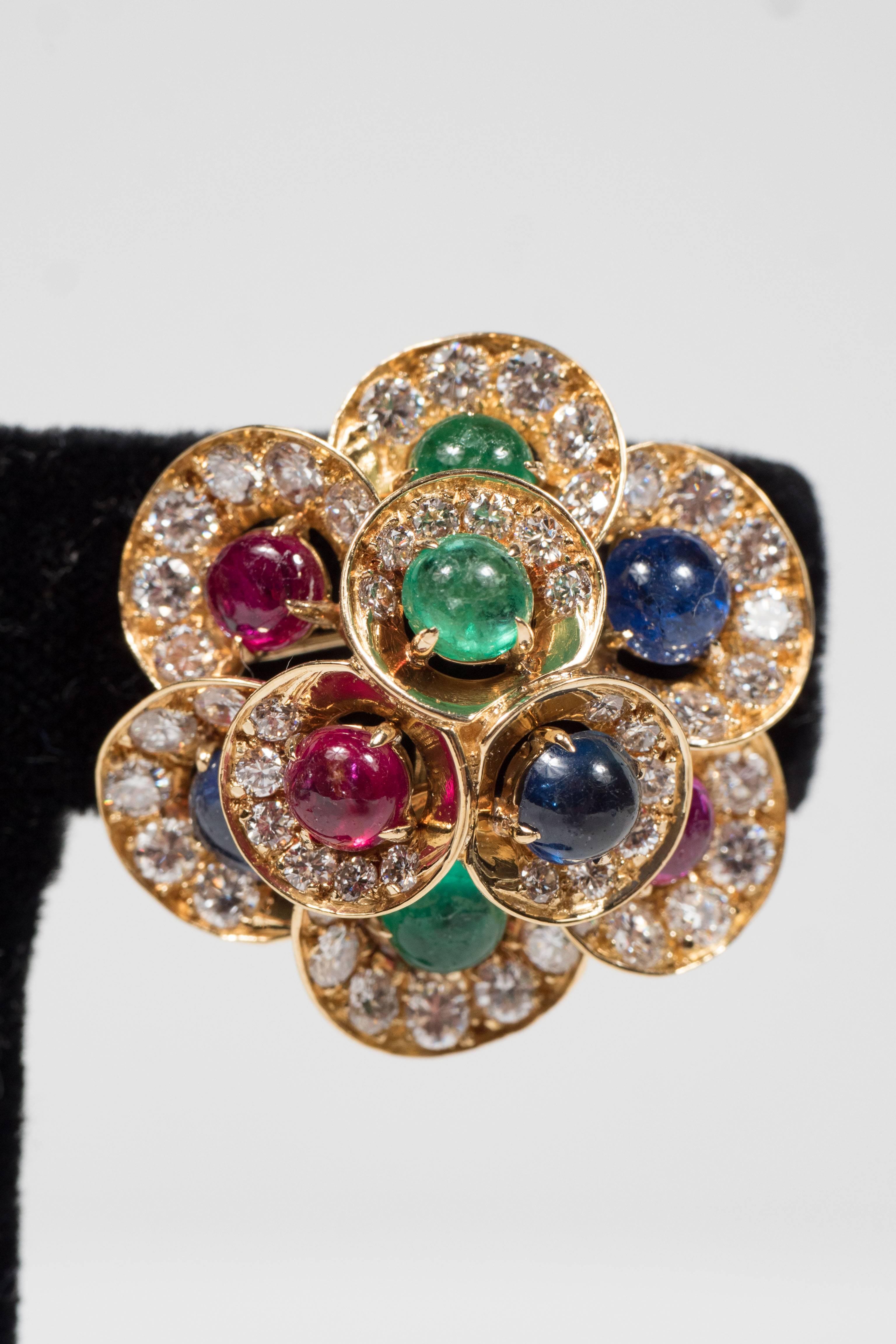 These stunning Mid-Century Modernist earrings are designed as clusters centering 3 ruby, 3 sapphire and 3 emerald cabochons measuring 4.5 mm, the cabochons surrounded by 120 round diamonds weighing approximately 5.25 carats, with a gross weight of