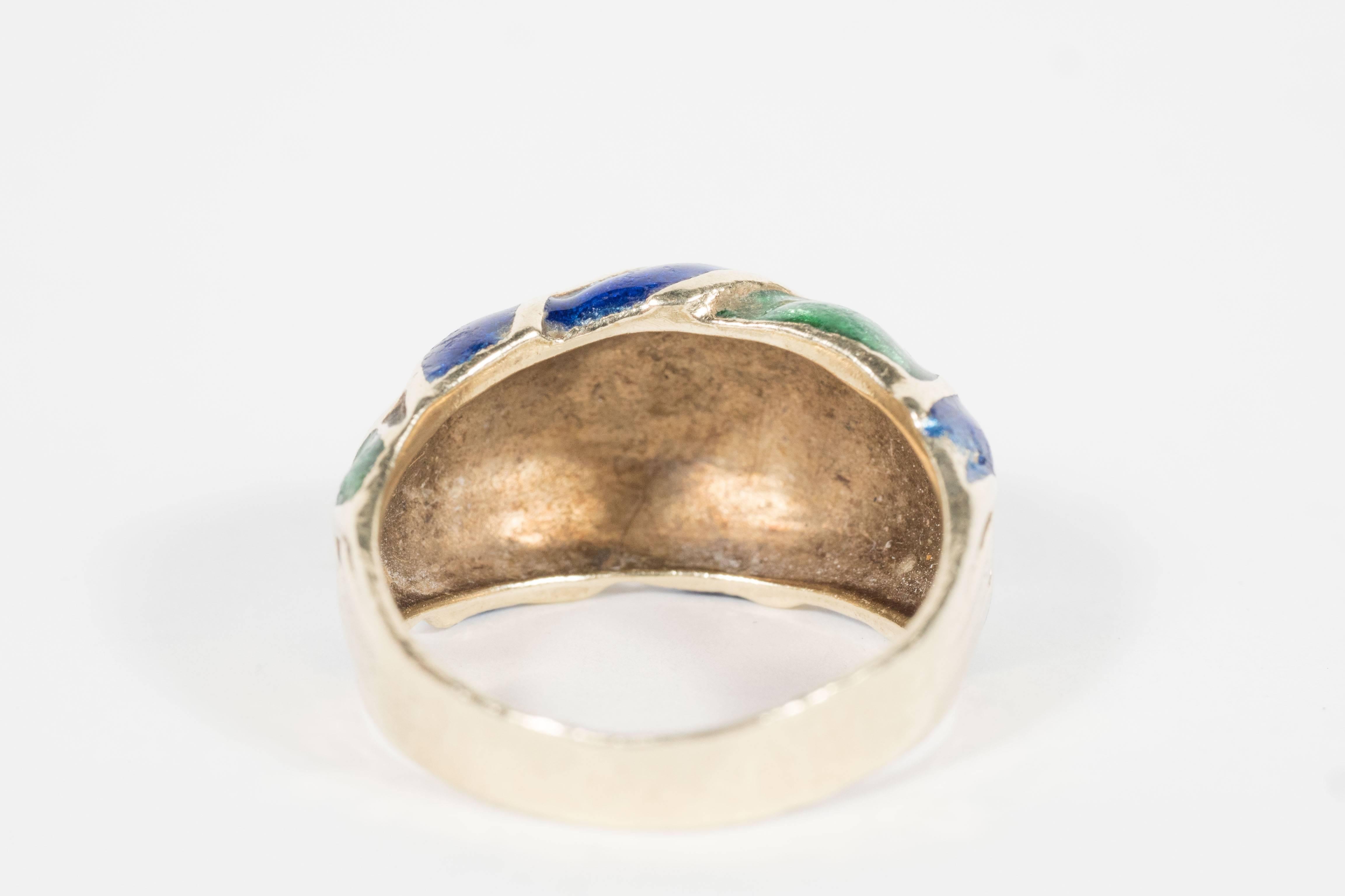 This beautiful ring features a braided knot design accented in blue and green enamel all set in 14k yellow gold.This ring is currently a size 7 but any jeweler can size to suit. It weighs 6 grams and is marked 14k as well.