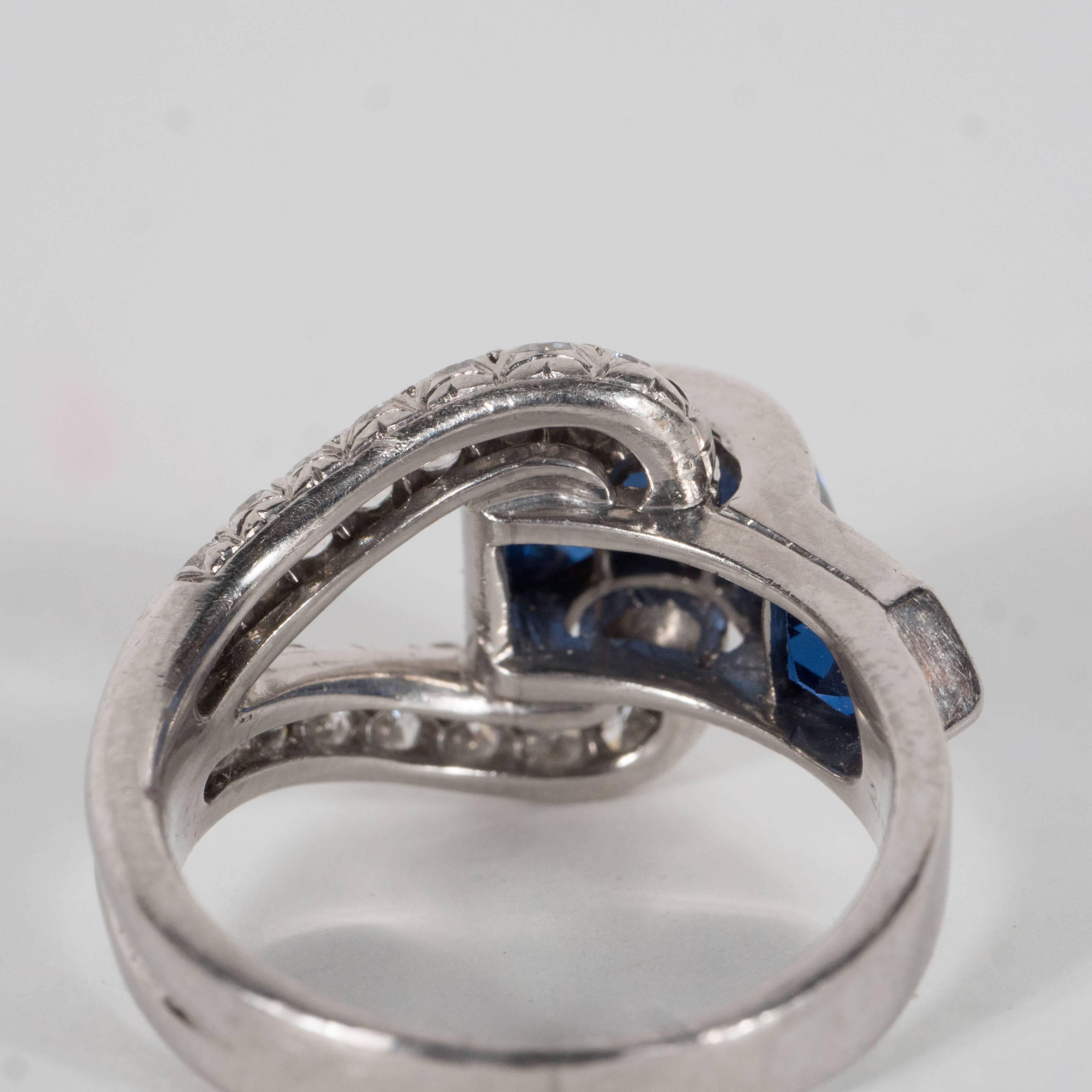 This stunning ring features 4 fine Burmese sapphires with 28 full cut European diamonds all set in a buckle design in platinum. It weighs 6 grams and is a size 6 but the buyer can size to suit. It is made in the United States Circa 1935.