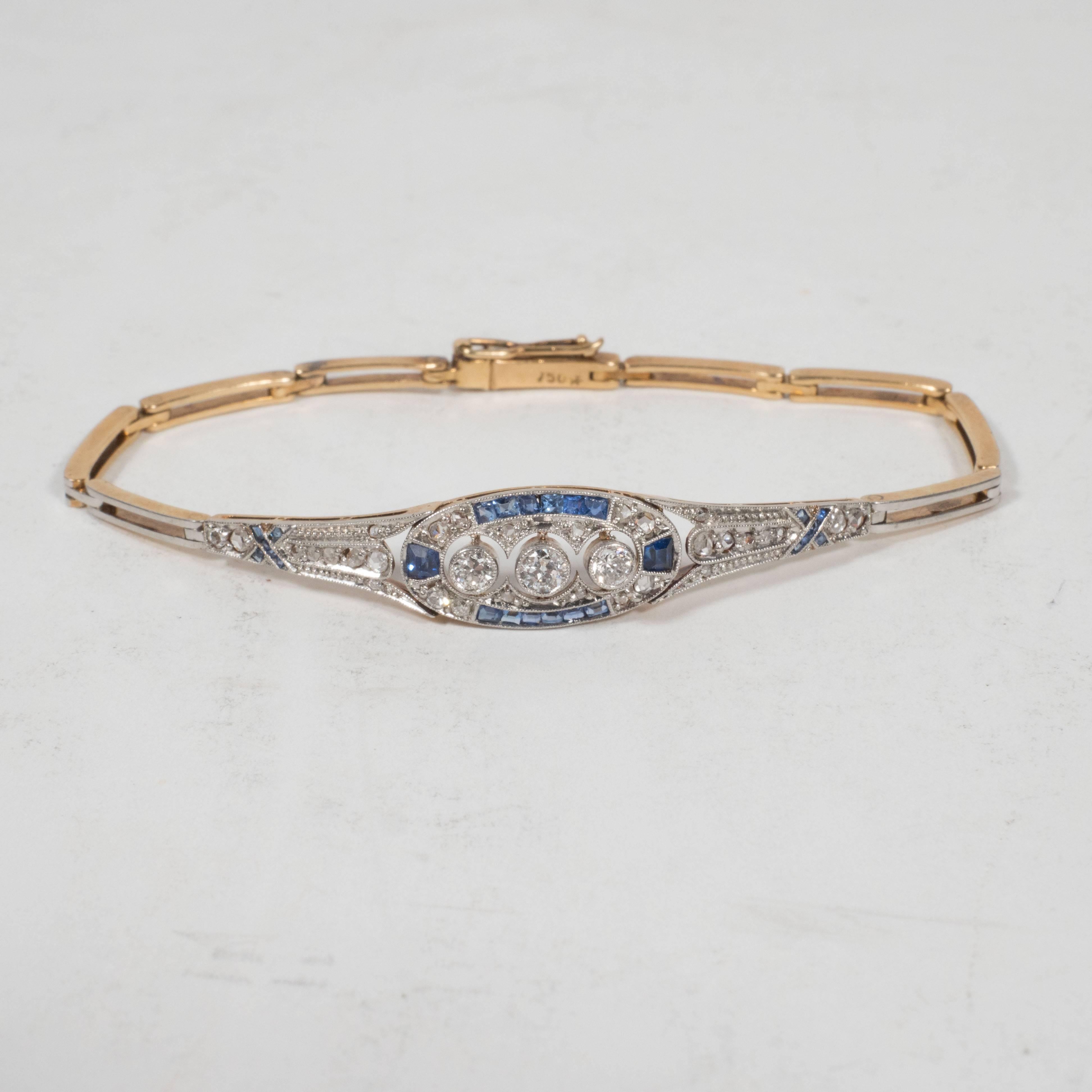 This exquisite 14k gold bracelet features fastidiously filigreed links with Baroque designs as well as foliate and floral designs throughout. The central link includes a .03 point old mine cut diamond flanked on either side by two square sapphires,