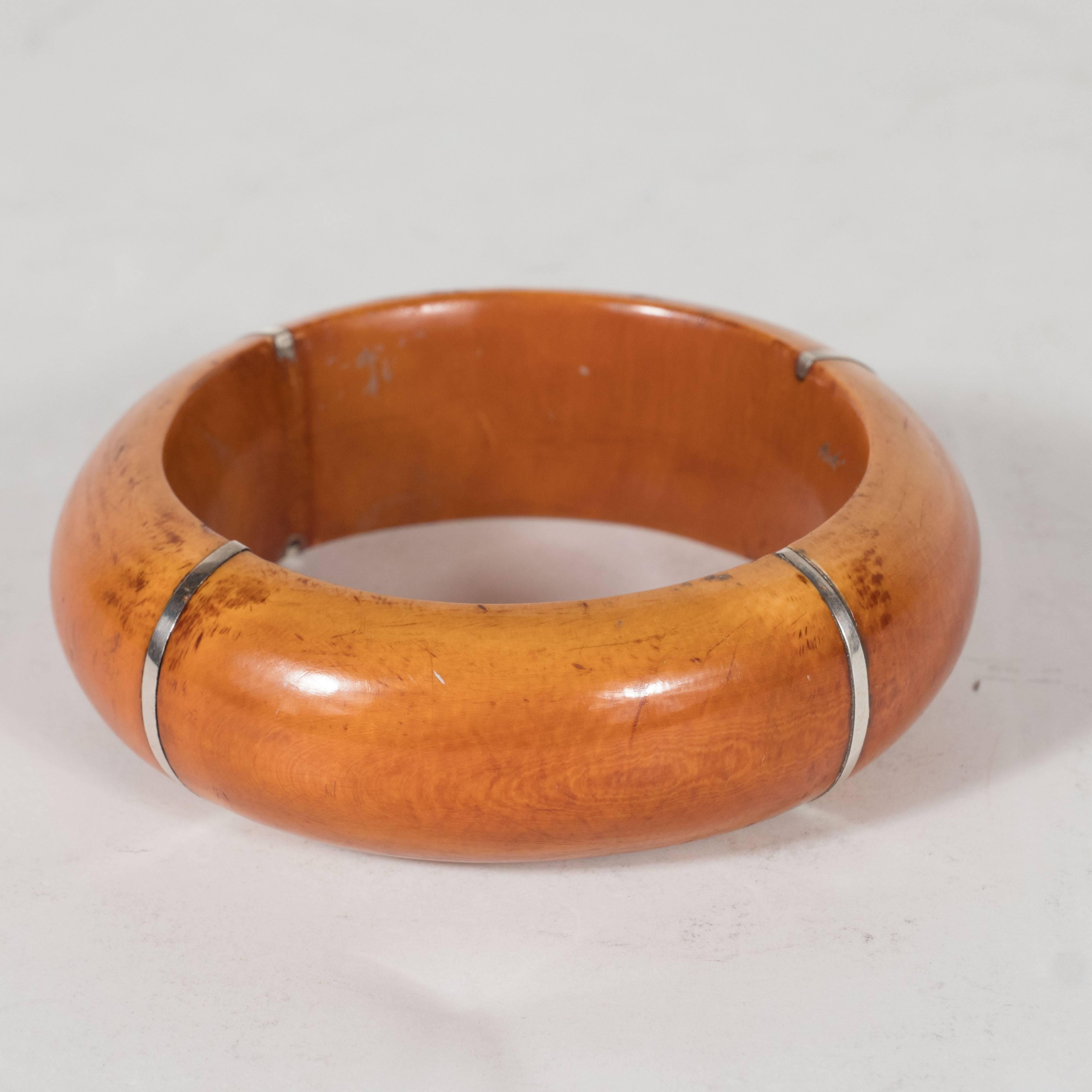 This refined bangle bracelet is composed of a tea stained bone in a rich Manuka honey hue with sterling silver inlaid accents. This piece is a testament to the beauty of simple design. Composed of just two elements, sterling silver and bone, this