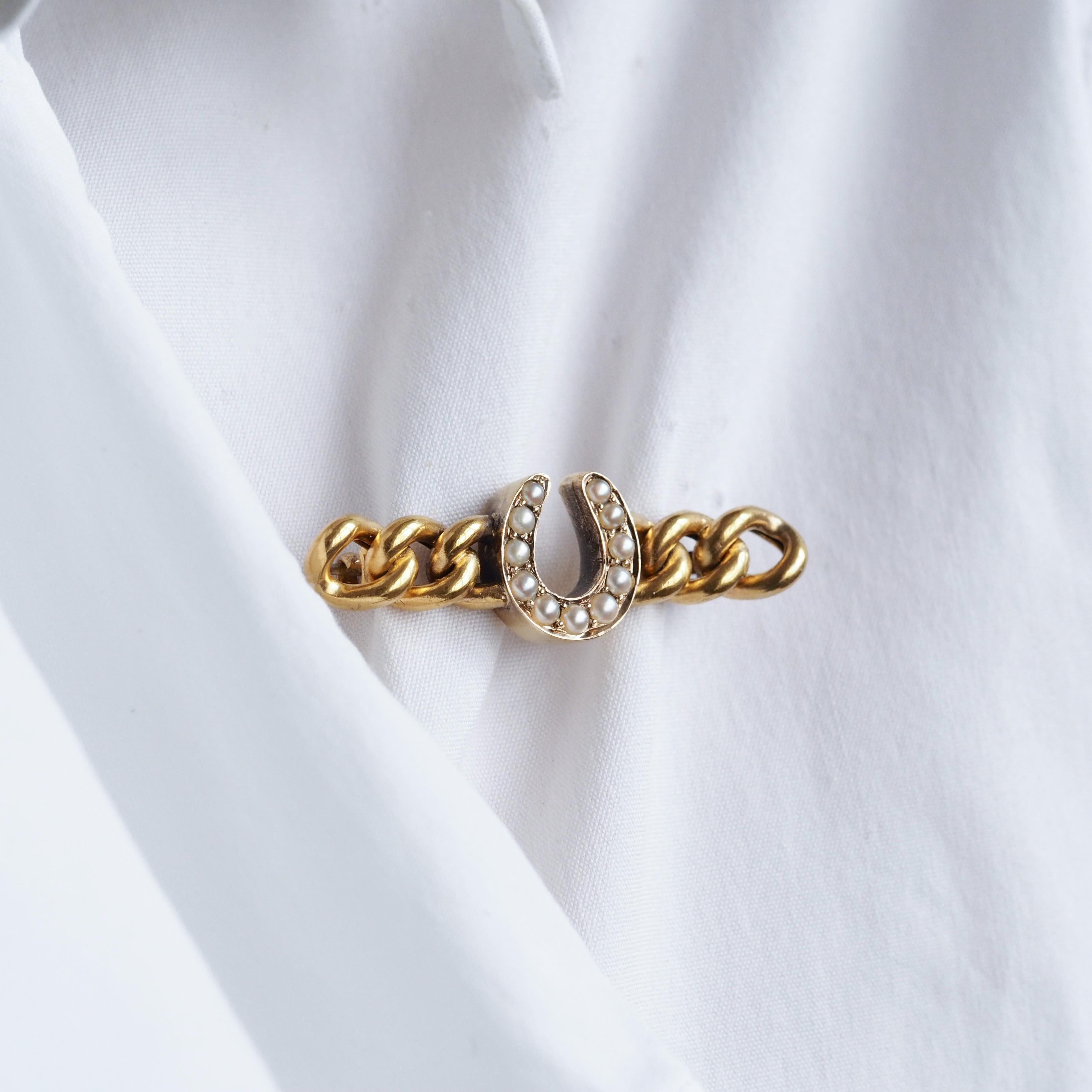 Wir freuen uns, diese liebenswerte antike viktorianische Perlenbrosche aus dem Jahre 1900 anbieten zu können.

Die Brosche ist aus massivem 15-karätigem Gold und in spektakulärer viktorianischer Manier gefertigt. Ein Hufeisen, verflochten mit einer