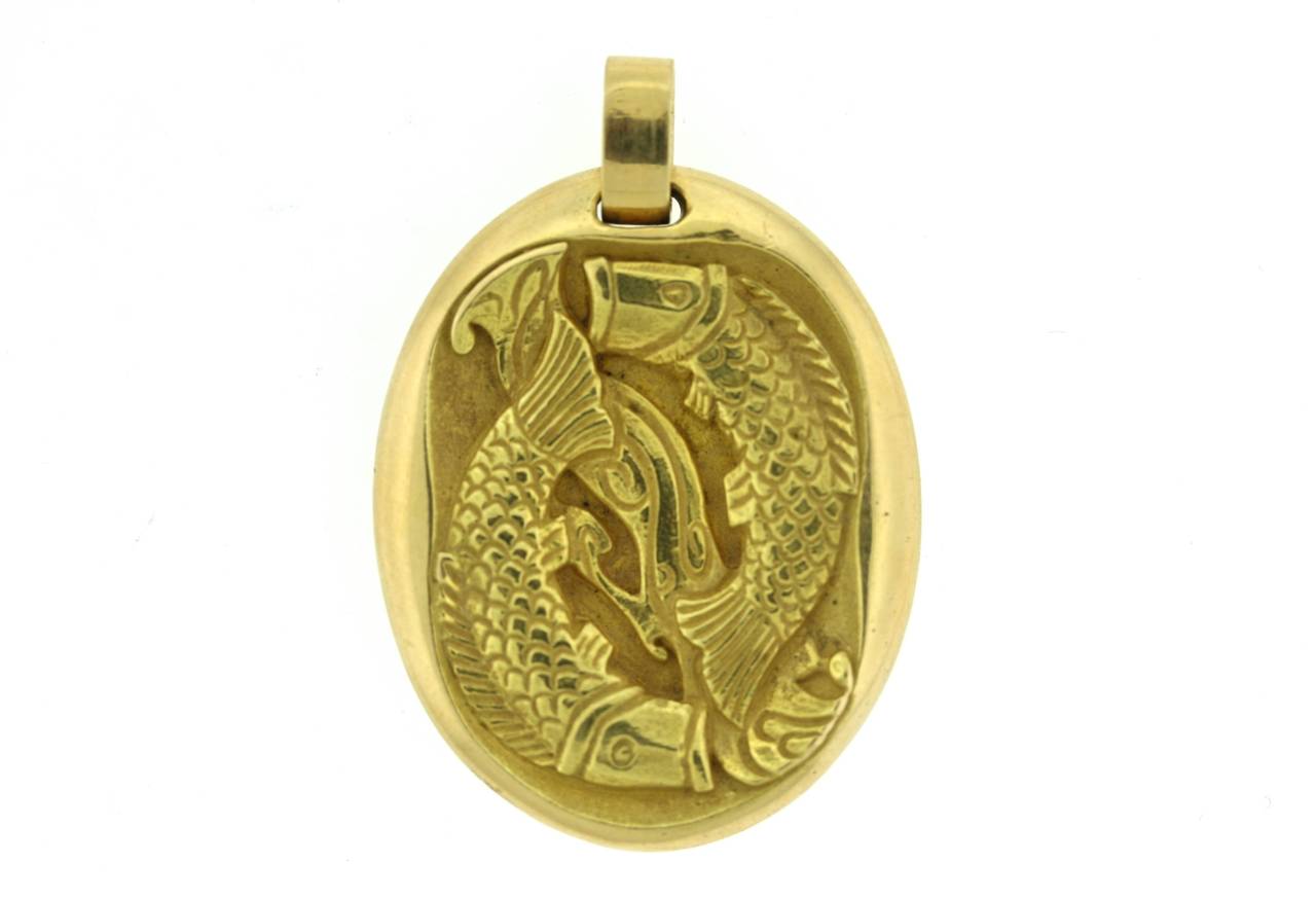 Cartier Paris 18k gold oval pendant bearing the motif of the zodiac sign Pisces. The reverse side of the pendant bears the Greek symbol for the sign. 1.75