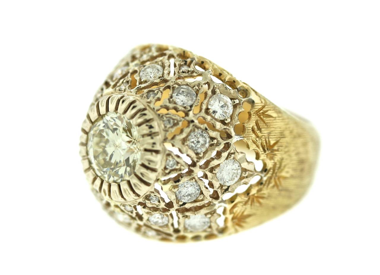 An elegant 18k brushed gold ring of a dome shape centering an old mine cut diamond surrounded by 20 smaller diamonds set into the delicate hand-forged piercing work Buccellati is world renowned for. While this piece boasts all the comfort,