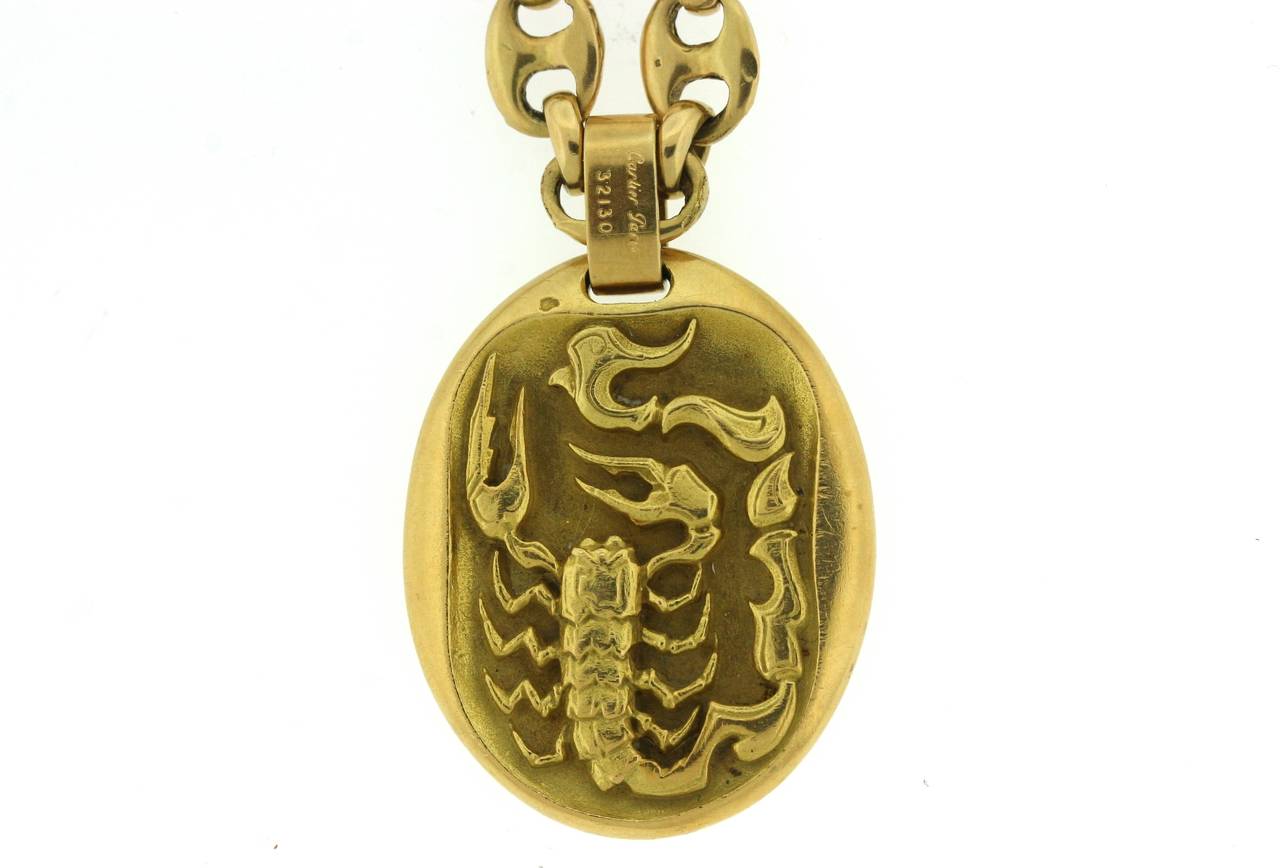 Cartier Paris 18k gold oval Scorpio zodiac pendant. The reverse side shows the Greek symbol for the Scorpio sign. 1.35' long (not including bale) and 1.2