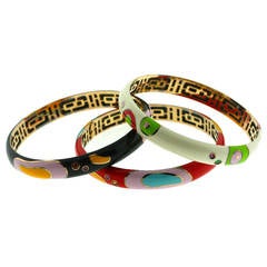 A Set of Three Enamel Gem Set Gold Bangle Bracelets