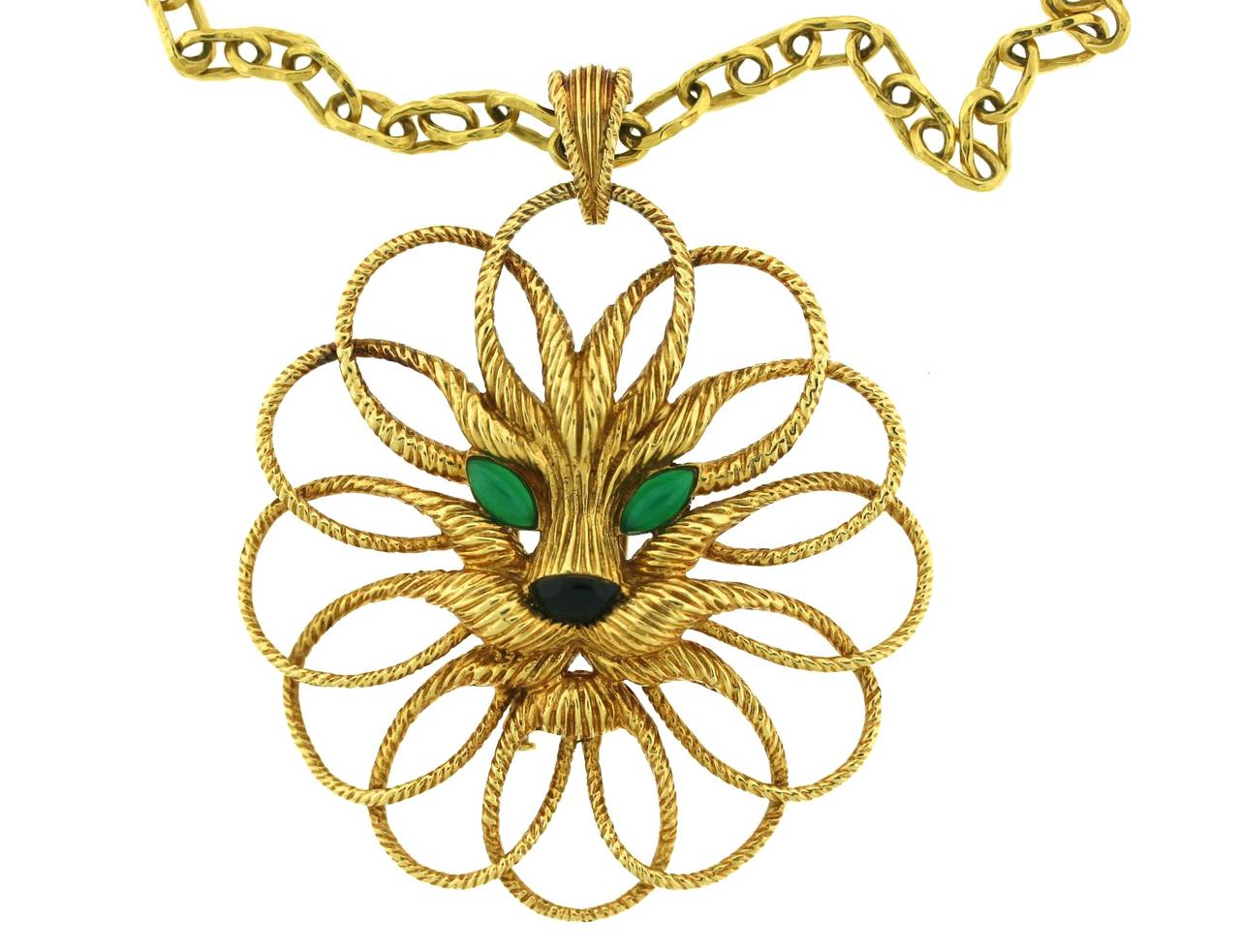 Van Cleef & Arpels 18k gold pendant designed as a circular-shaped lion's head with chrysoprase eyes and a black onyx nose suspended from a long hammered gold elongated oval link chain. The lion's mane and whiskers are worked into oval loops of