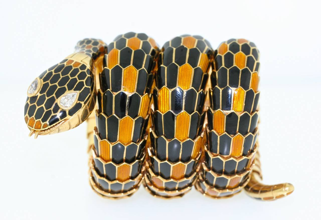 Bulgari 18k gold serpent bracelet watch designed as a triple coil of hand enameled and articulated scales in a two tone pattern of jet black opaque enamel contrasting with a golden translucent enamel. Two pear shaped diamond eyes are bright and