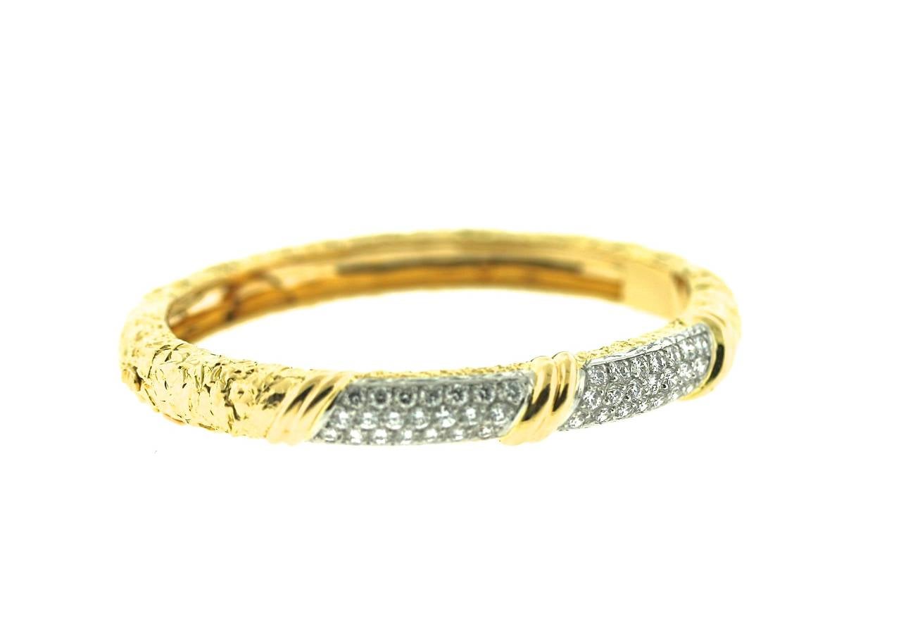 Van Cleef & Arpels 18k textured gold hinged bangle bracelet with two pave diamond sections with 42 diamonds for an approximate total weight of 2 carats. Internal circumference of approximately 7