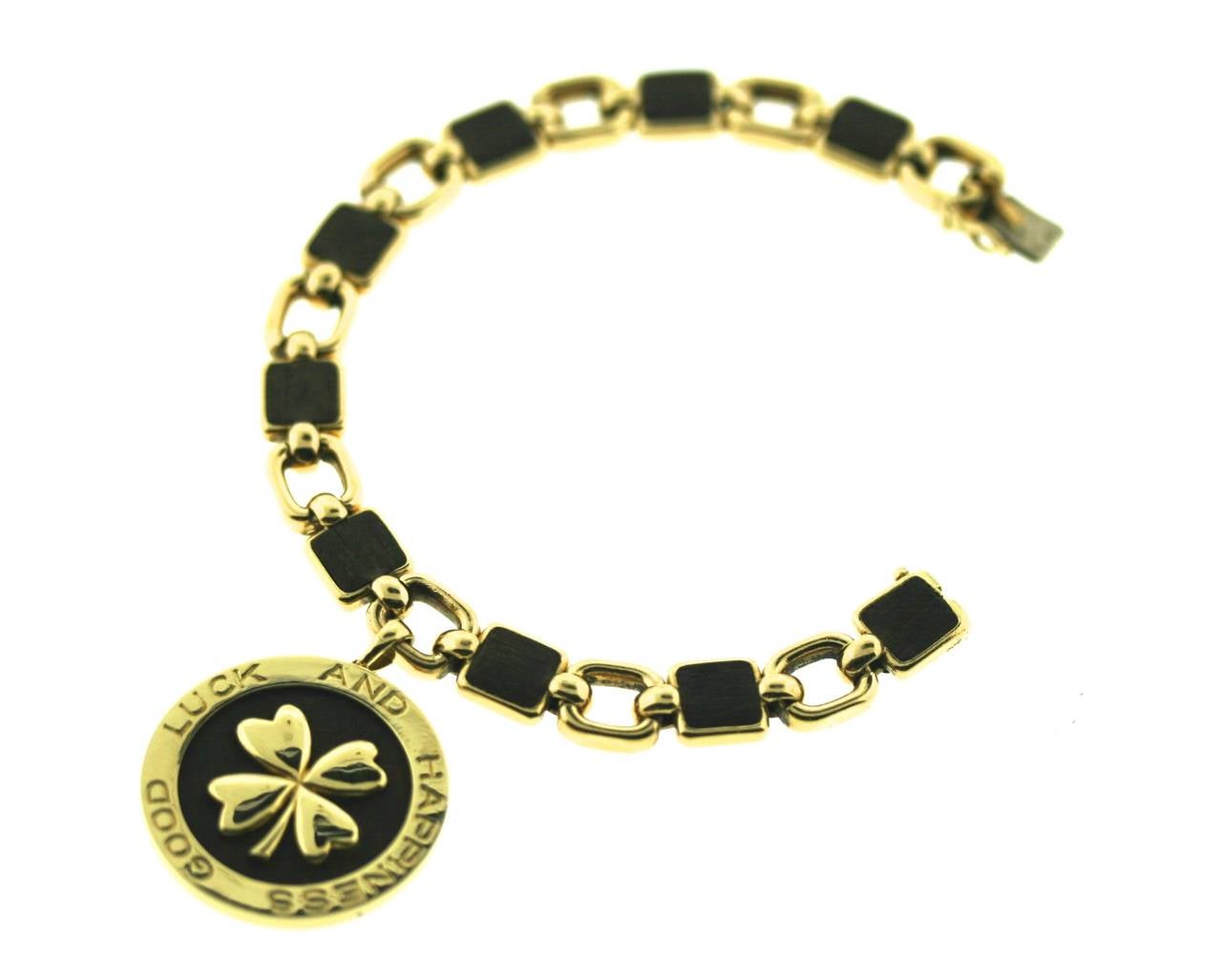 A very special symbolic charm bracelet by Van Cleef & Arpels circa 1970s. This unique piece is designed as an alternating 18k gold and wood square link bracelet suspending a matching charm with a central four leaf clover motif--the symbol of the