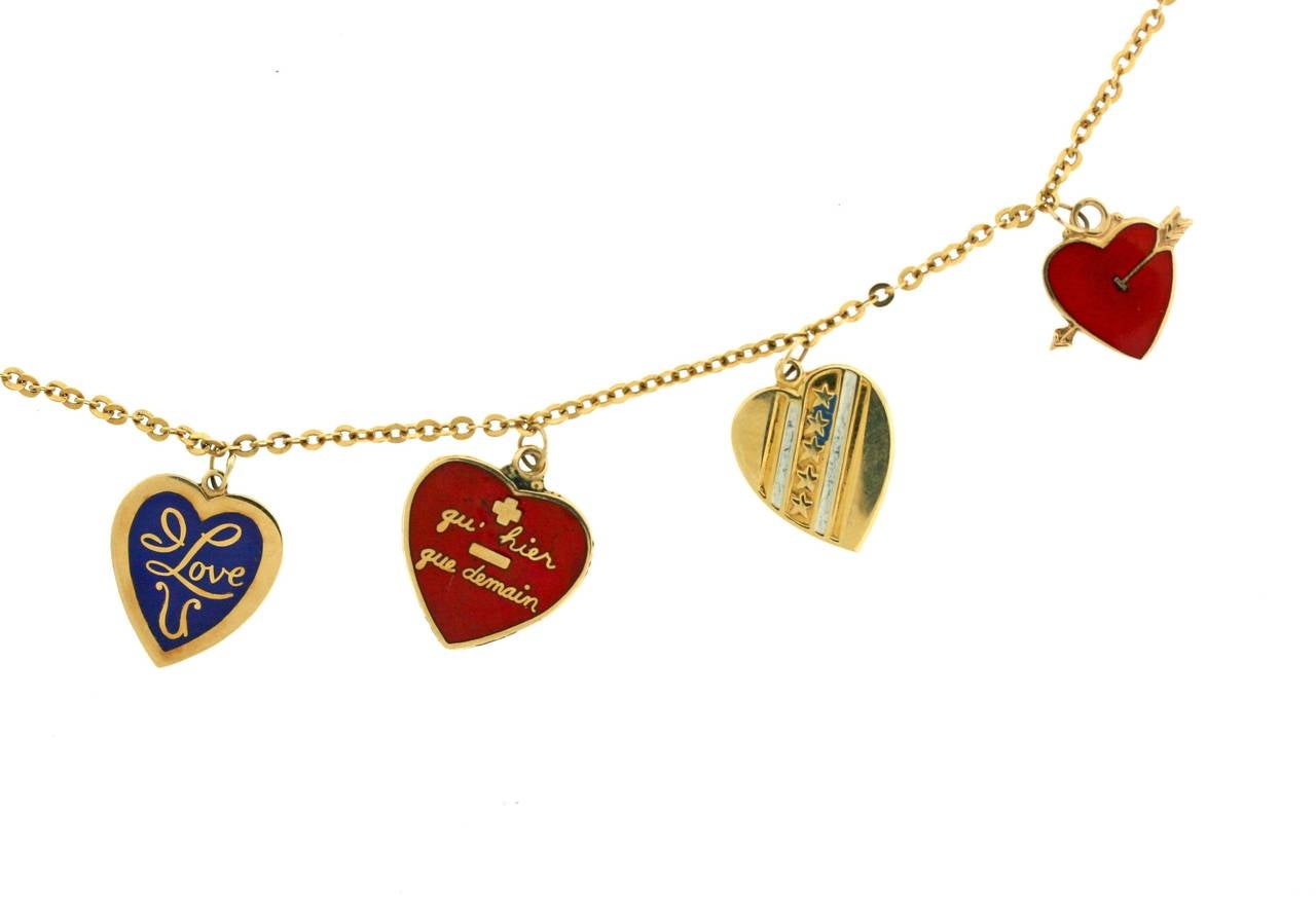 A symbolic gold neck chain suspending a variety of nine heart charms. Six are enameled, some have statements of love in French, some in English and three are simply golden hearts. Each is unique and meaningful. Circa 1960s. Measures 18