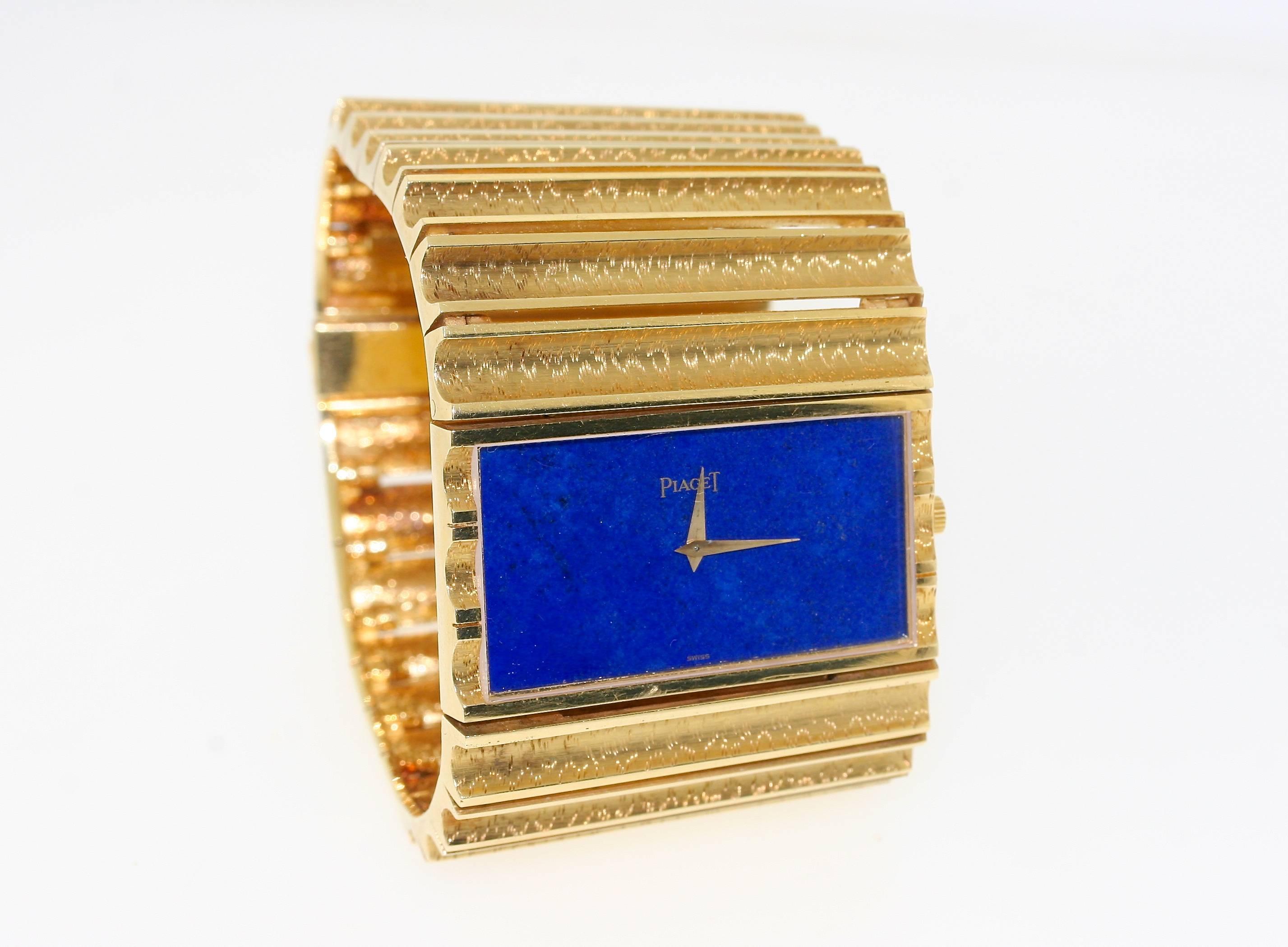 Piaget 18k gold bracelet watch designed as finely engraved, rectangular concave links articulated to bend to the shape of the wrist centering a rectangular lapis stone face. 1.75