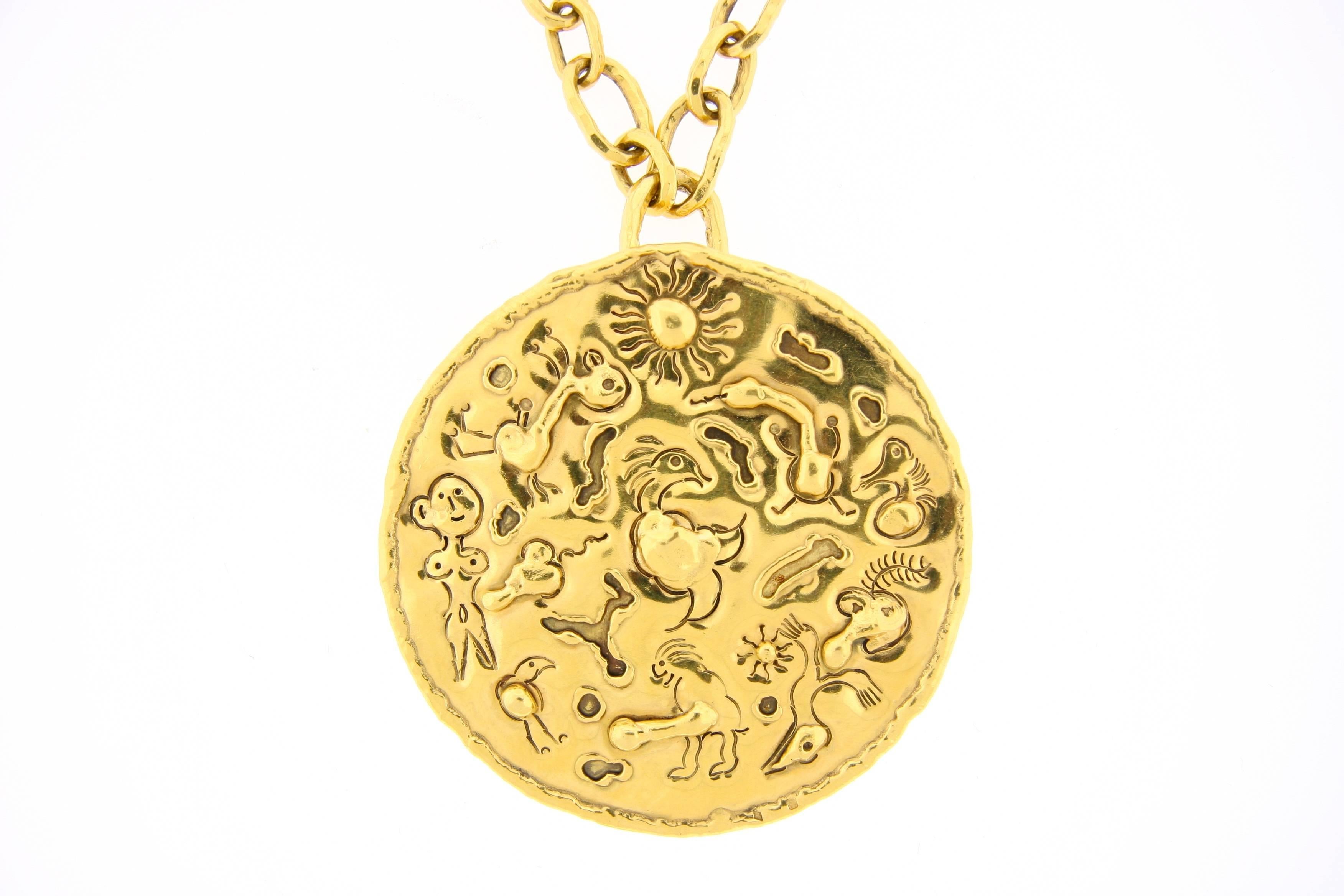 Jean Mahie handmade 22k gold necklace designed as a hammered, graduated, oblong link chain suspending a detachable round pendant of engraved and applied gold work. Chain is 15
