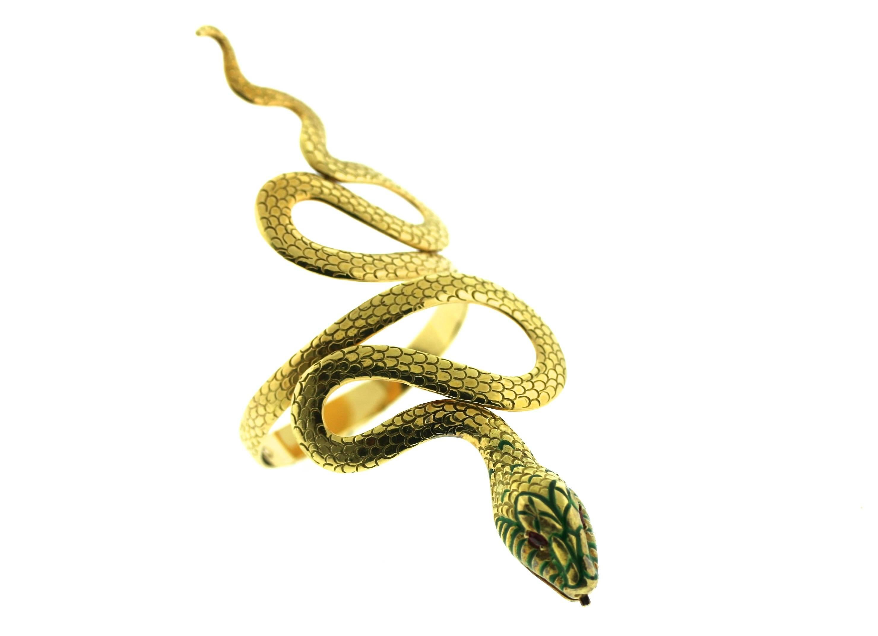 Spritzer and Fuhrmann 18k gold hinged serpent cuff with faceted ruby eyes and green enamel detail on the head. The body is engraved with scales all around. This is a wonderful statement bracelet measuring 5