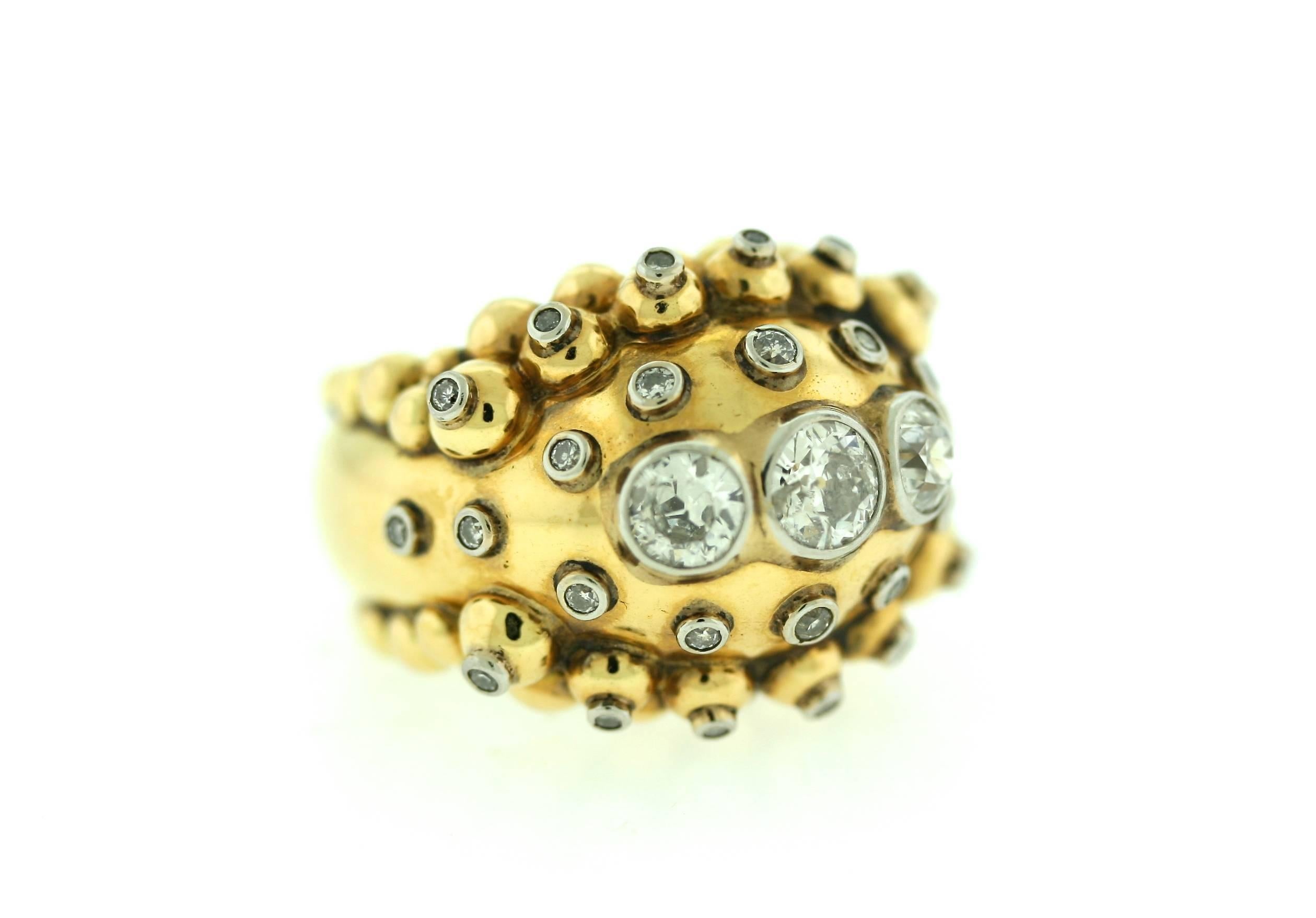 Stylish French 18k gold ring designed in a bombe stye with thee center stones totaling approximately 1.25 carats set in platinum surrounded by 12 raised diamond centered balls and 14 bezel set diamonds. Size 6.5-7. French hallmarks present.