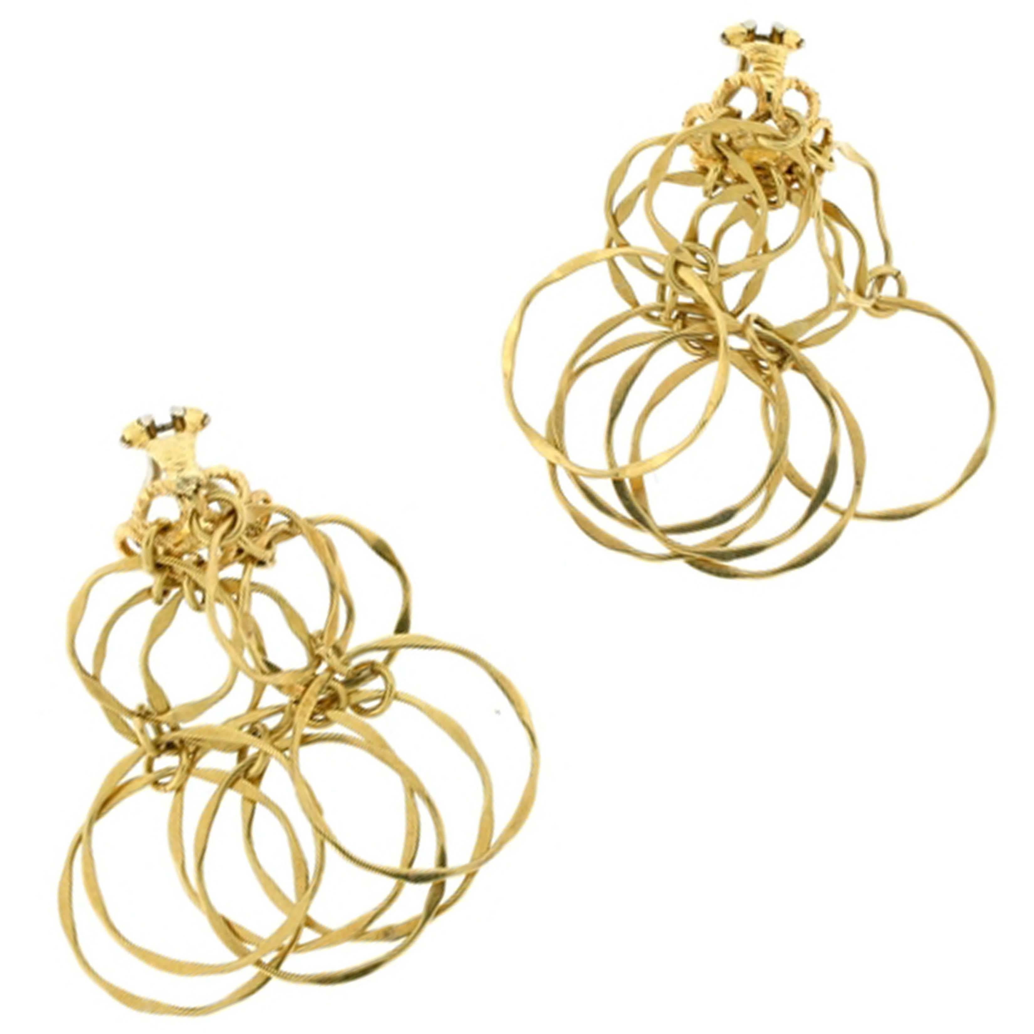 Six double-hoop tiers of hammered 18kt gold dangle from a textured, open-work ear-clip. The resulting earring is light, delicate and free. Overlapping circles lend the earring an open, airy depth; the tiers never lay exactly flat but rather jingle
