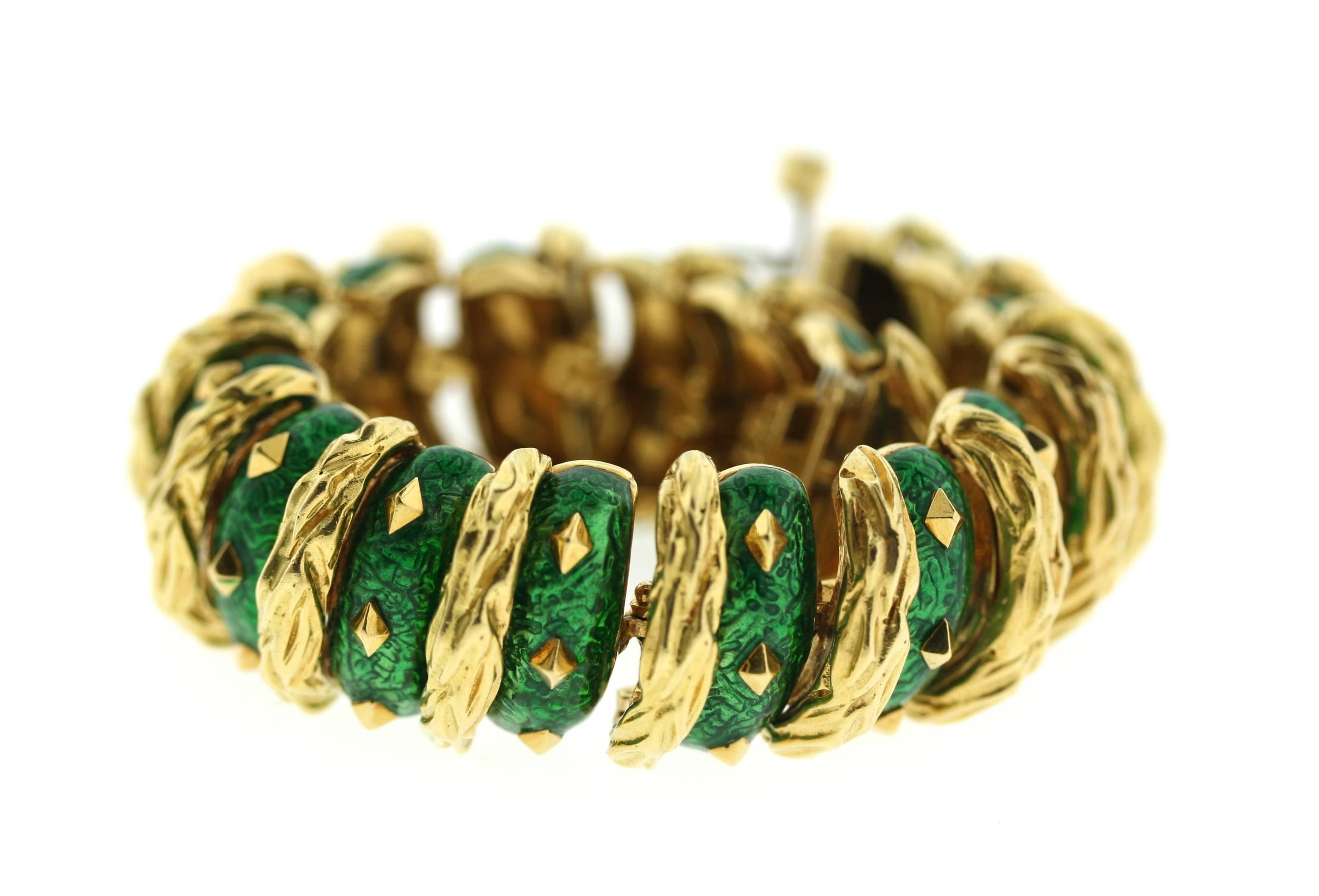 David Webb 18k gold bracelet with emerald green enameled links. Each link is set with diamond-shaped gold studs and separated by elongated sections of textured gold. When fastened the bracelet takes on the form of a semi rigid bangle which molds to