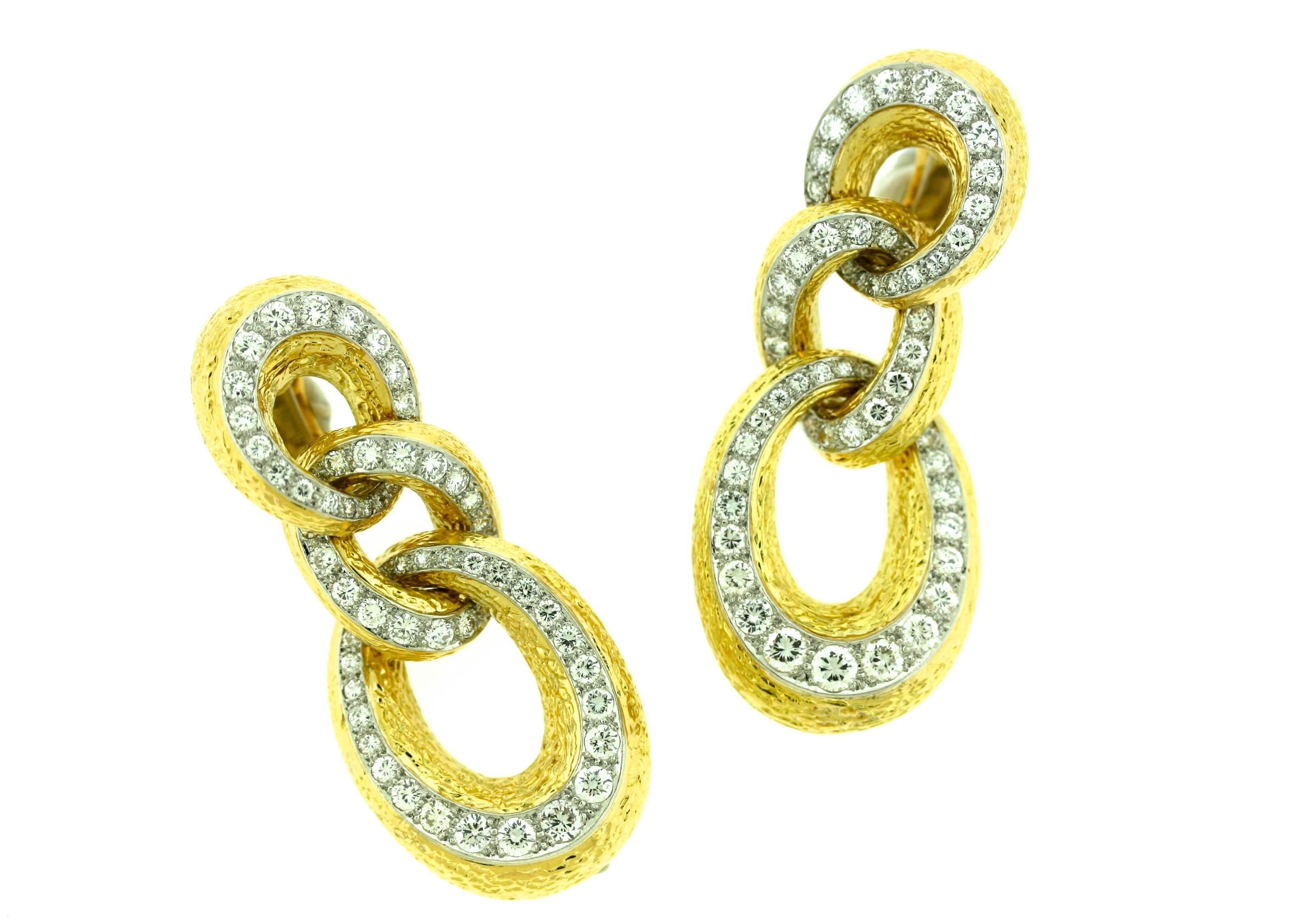 Van Cleef & Arpels textured 18k gold ear clips designed as three interlocking vertical oval hoops with approximately seven carats of diamonds set in platinum. 2.5