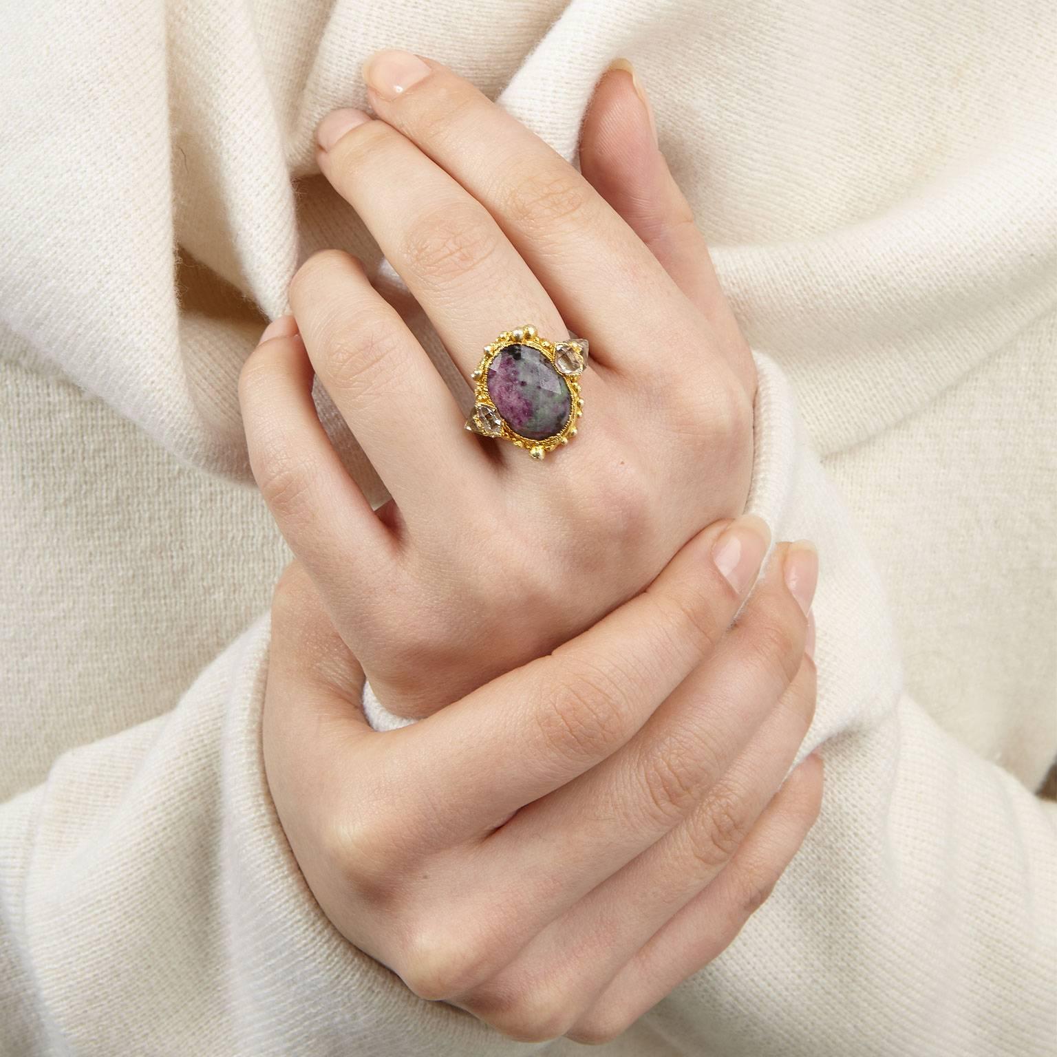 Revel in the regal beauty of the Queen Anne's Revenge ring. A rose-cut ruby zoisite stone sits at its centre flanked by herkimer crystals on either side, encrusted in granules of gold plated silver atop a hammered band. Stunning and fierce in equal
