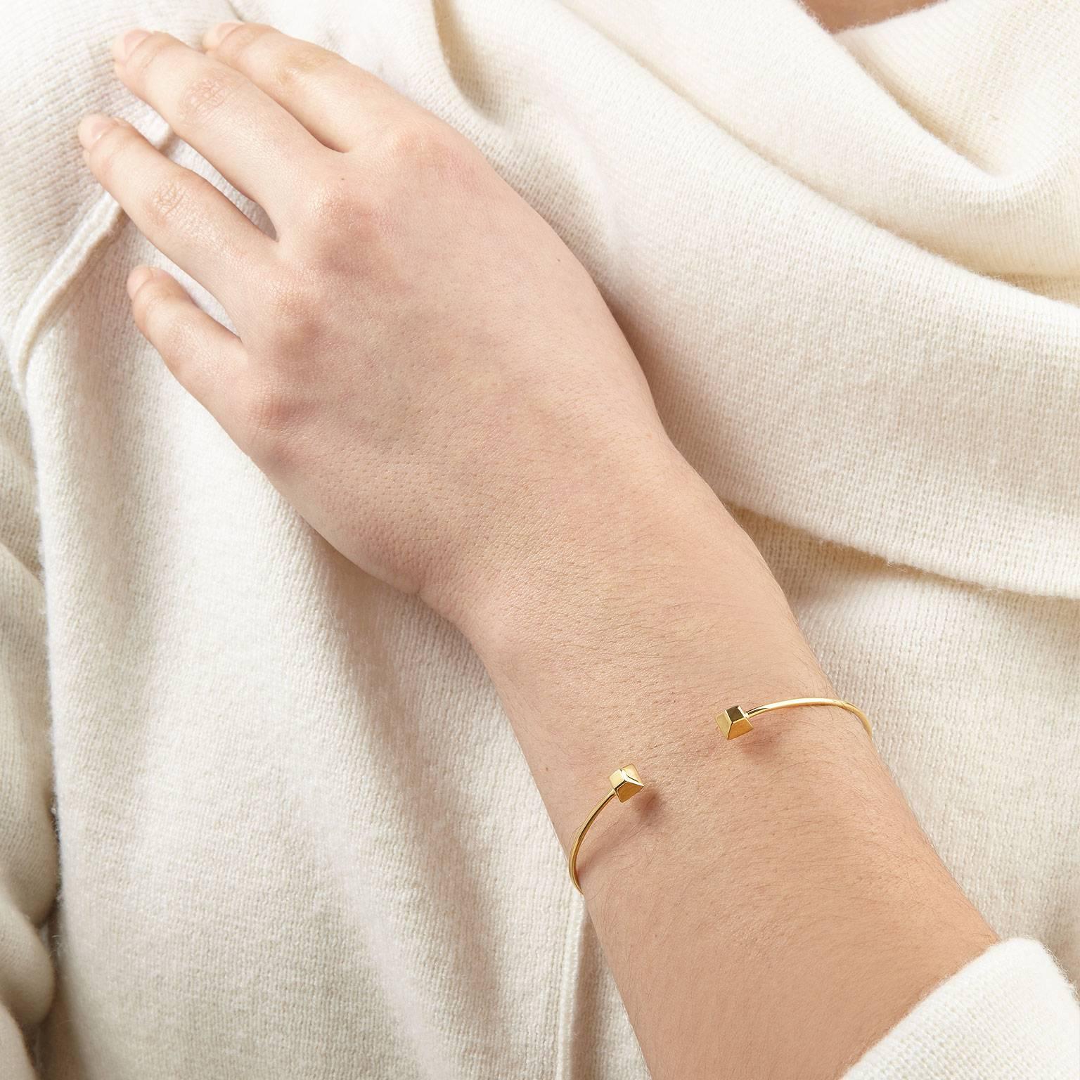 Architectural simplicity shapes this minimalist pyramid wire cuff. It is forged to bend, allowing you to slip it on effortlessly without a hinge. Wear it alone or with a selection of cuffs and bracelets stacked together.

Crafted in solid 18k yellow