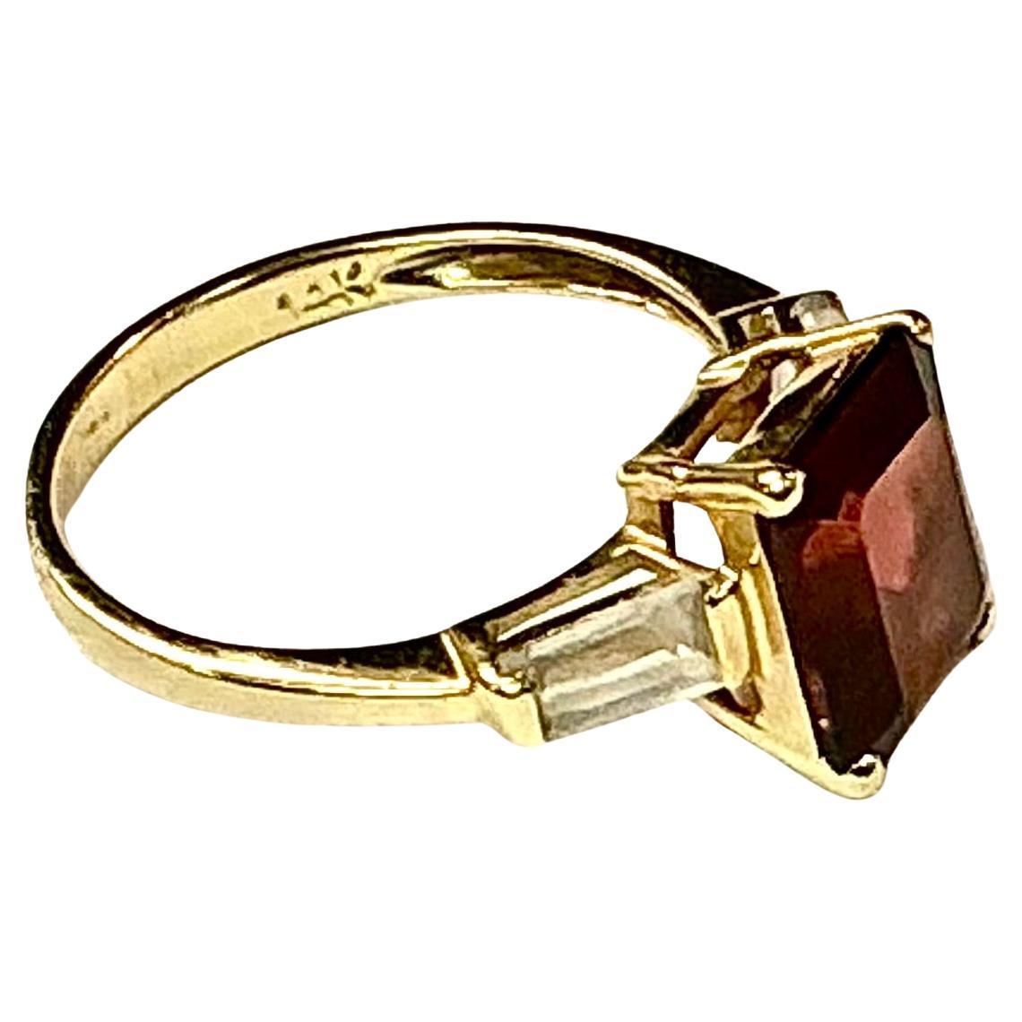 bague en or jaune 14k grenat taille émeraude, 2,09 grammes TW. Les dimensions du grenat taille émeraude sont d'environ 8,5 mm x 6 mm. Environ 2 carats. Marqué 14K. Taille approximative 5.0.