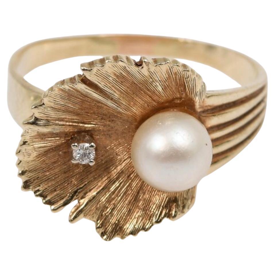 14K Pearl And Diamond Ring. 14K yellow gold ring contains 1 round brilliant cut diamond. WEIGHT: .02 Ct. Approx. Rated SI in clarity and H-I in color.  One 7.00 mm cultured pearl is epoxy set. the diamond is prong set. Weight: 5.7 grams.  Size: 10