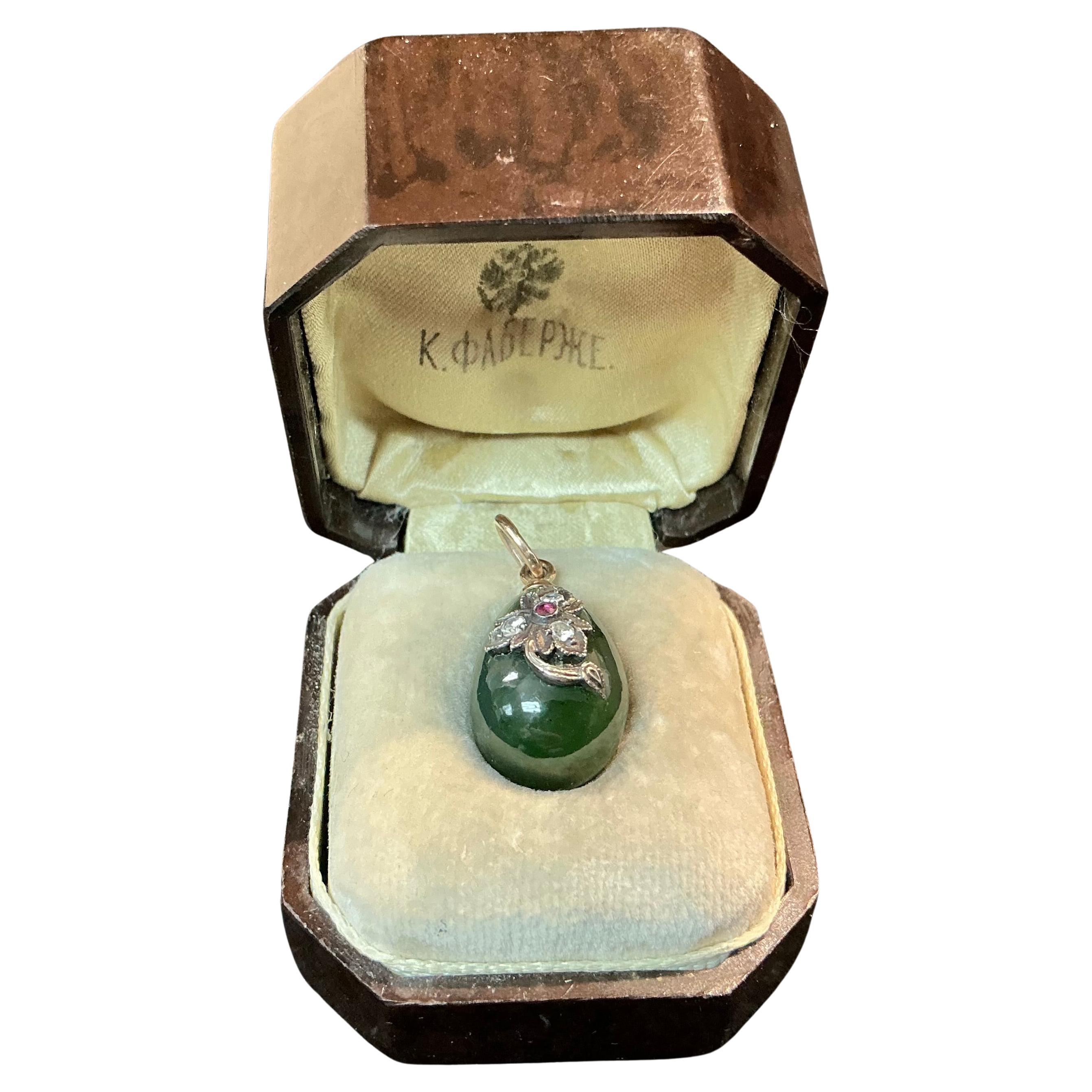 Inizio XX secolo, Russia Ciondolo a forma di uovo di giada Faberge in oro 14k e nefrite. Il ciondolo presenta un motivo a foglia in oro bianco con al centro un piccolo rubino taglio rotondo, mentre ogni foglia è impreziosita da piccoli diamanti