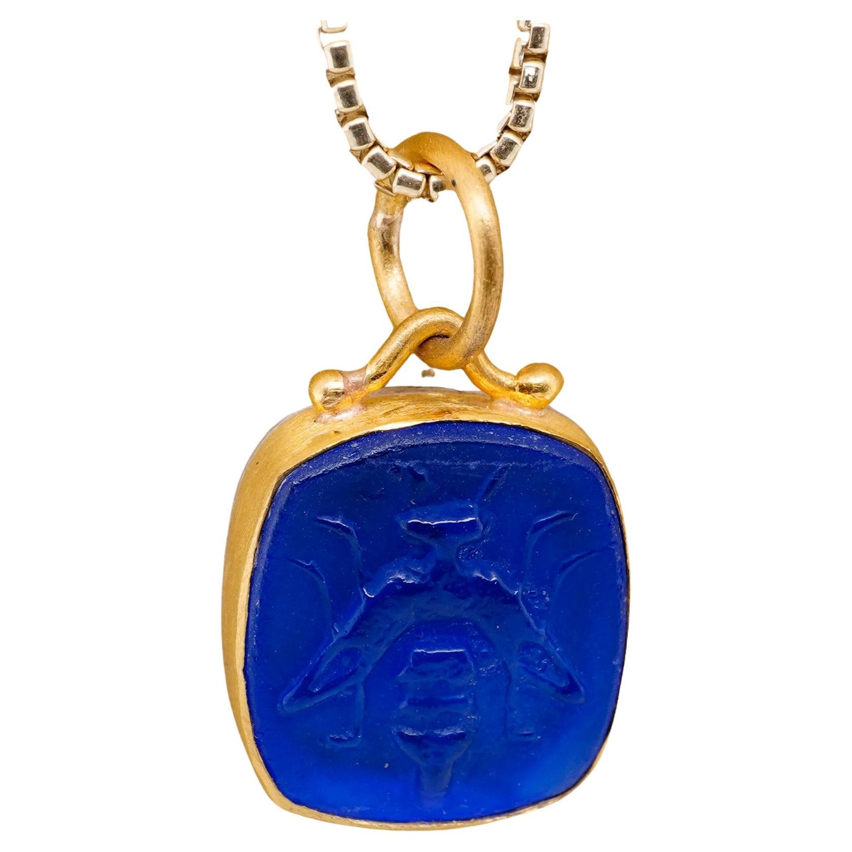 Blue Intaglio Bee Pendant, 24K Gold Framed Necklace by Prehistoric Works of Istanbul, Turkey. These pendants look great alone or paired with other coin pendants or with miniature pendants. Measures 12mm x 16mm. Pendant comes with a 16