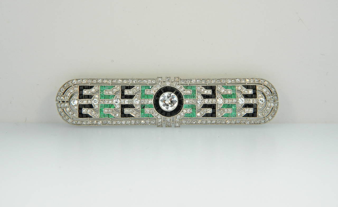 1920s Art Deco platinum, diamond, emerald and onyx brooch.  A fabulous example of Art Deco design and superior craftsmanship.